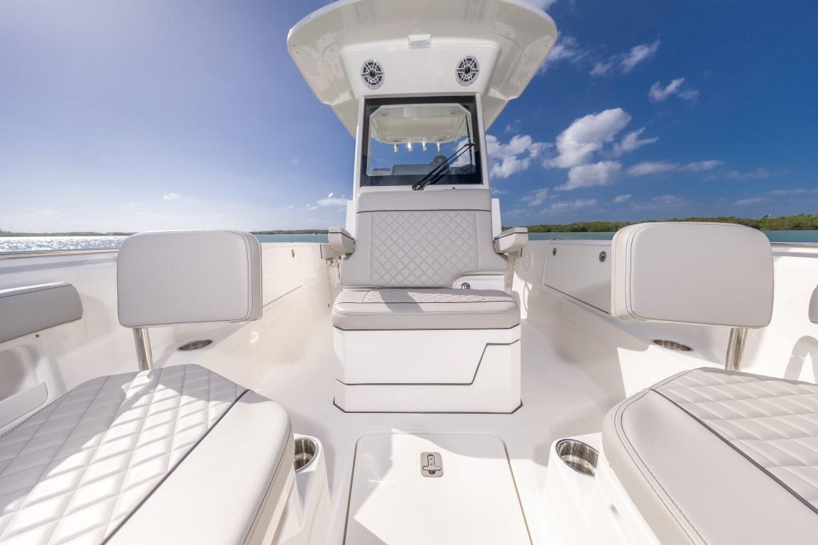 2026 Pursuit S 248 Sport boat interior with luxurious seating and clear blue sky.