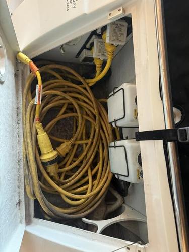 Coiled yellow power cable in 2005 Four Winns 298 Vista boat compartment.