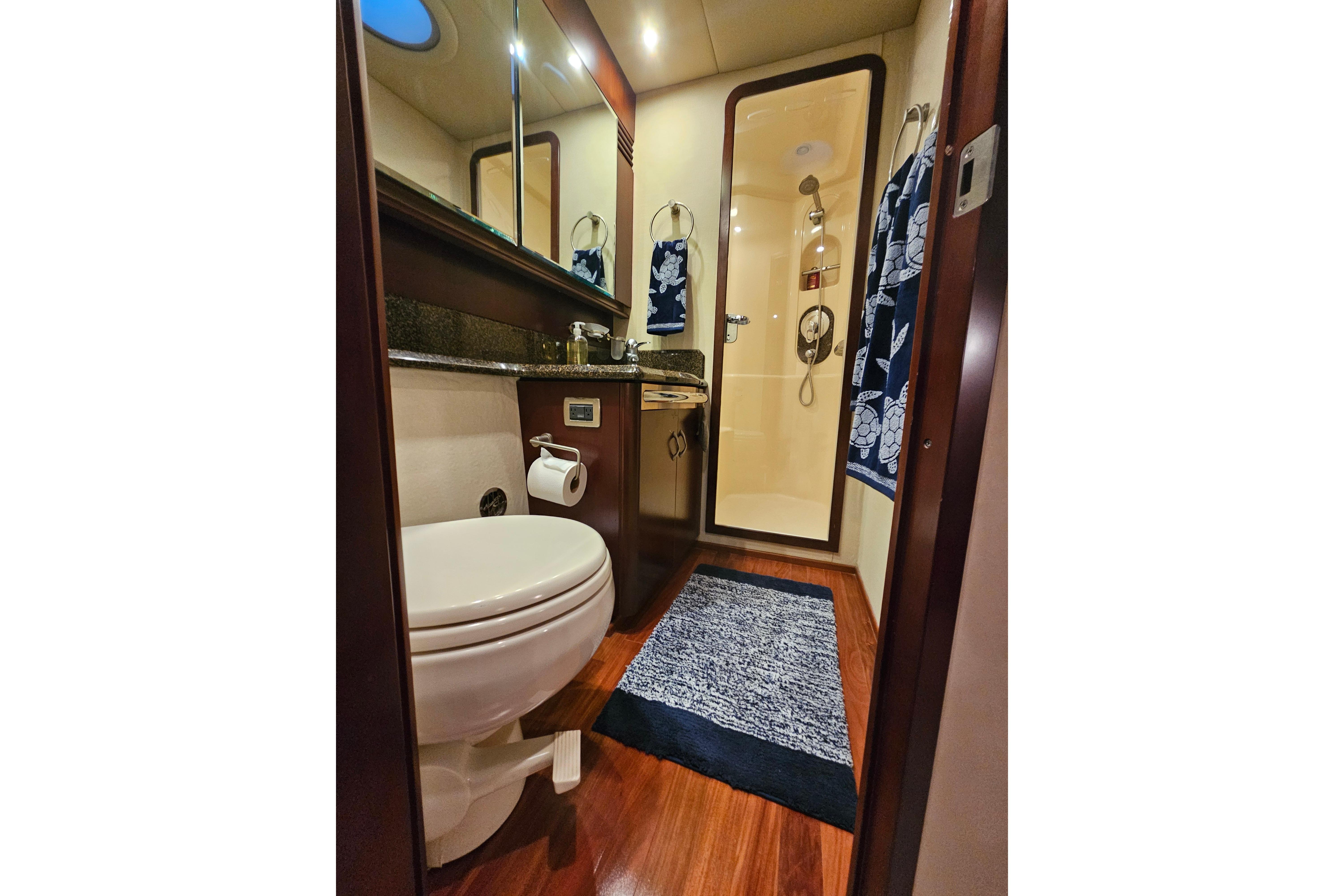 Luxurious bathroom in 2006 Sea Ray 580 Sedan Bridge yacht with elegant wood flooring.