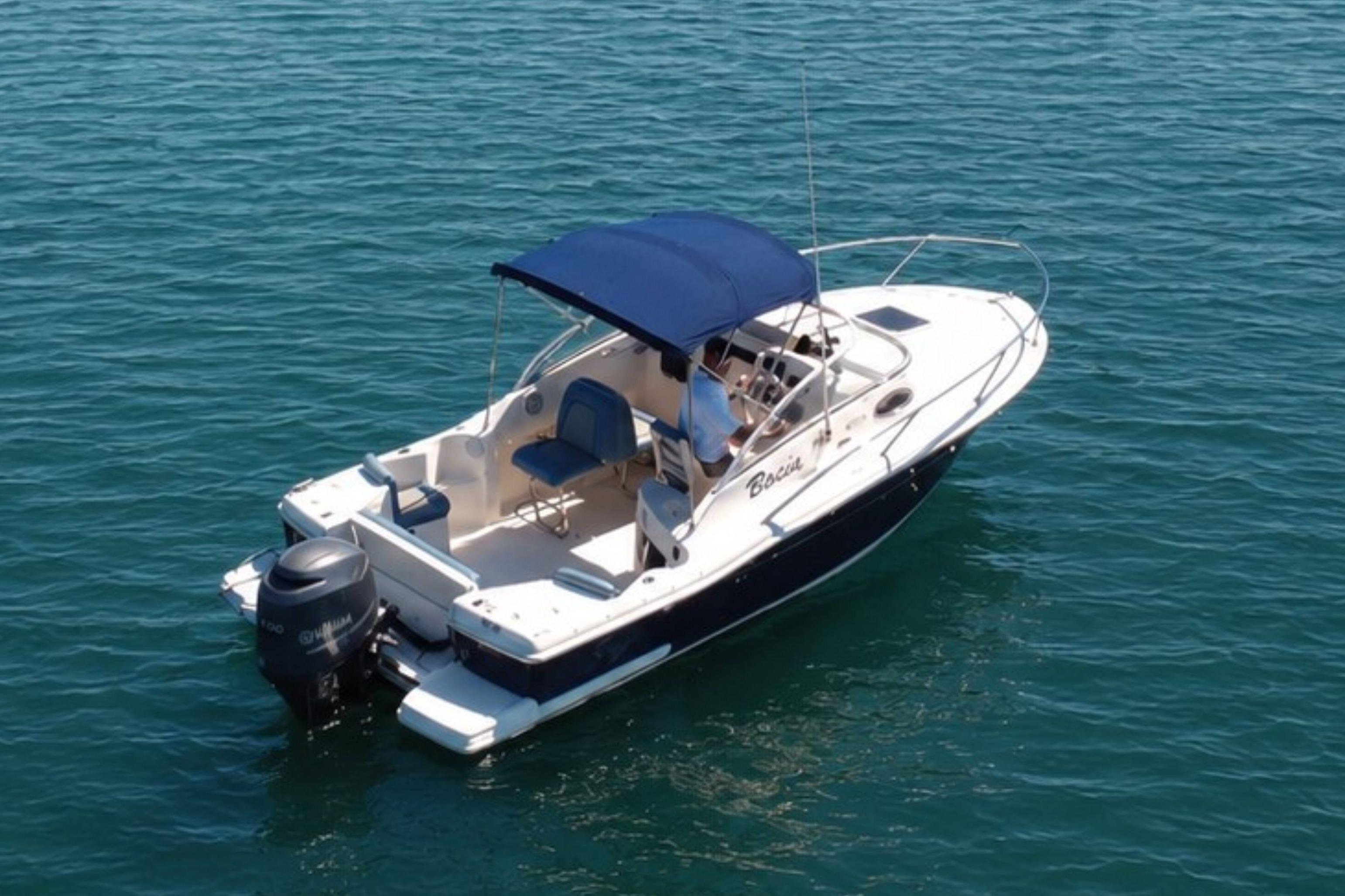 2008 Scout 222 Abaco boat with blue canopy on calm water.