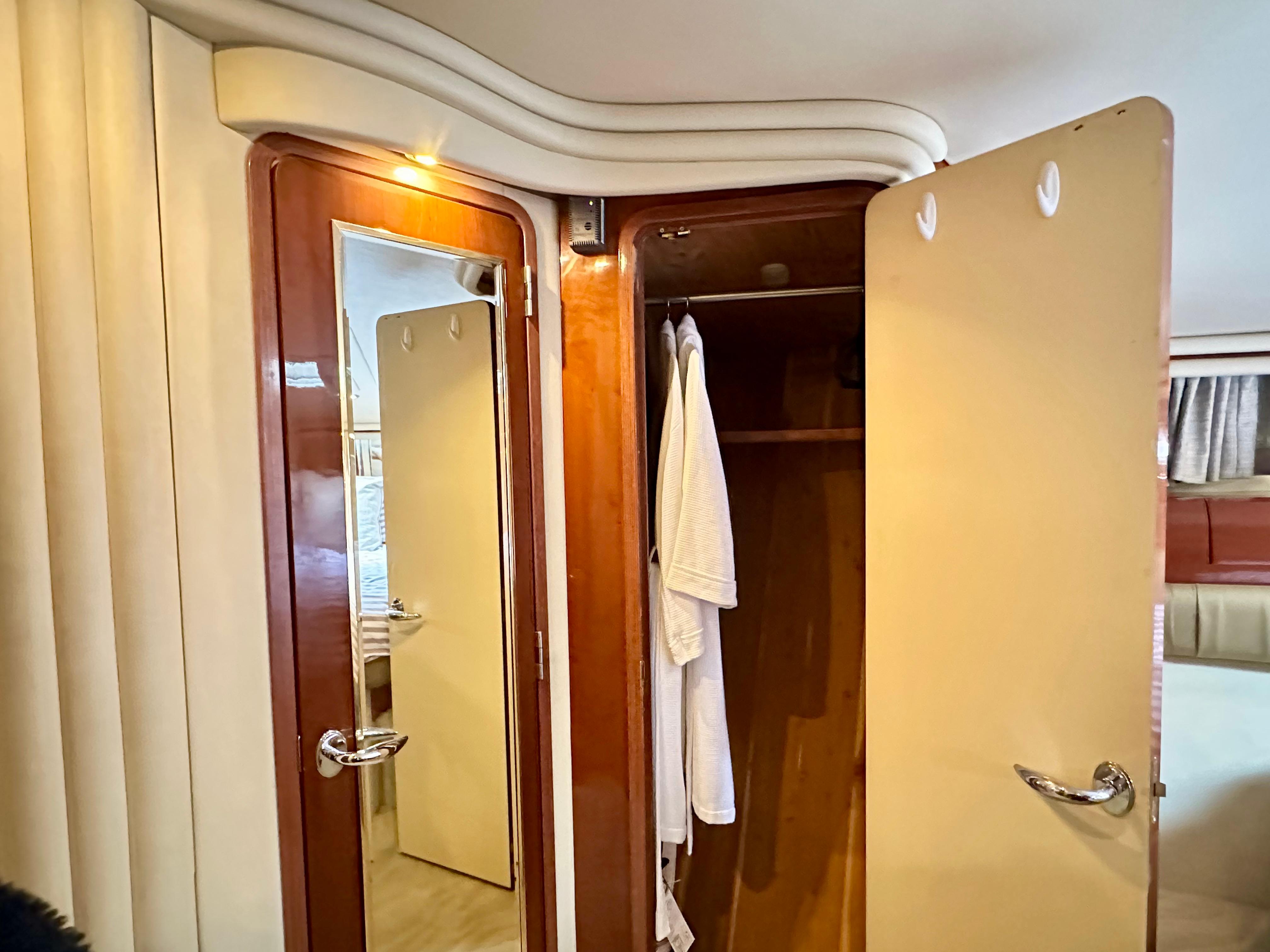 Luxurious 2002 Sea Ray 560 Sedan Bridge interior with wooden closet and mirror.