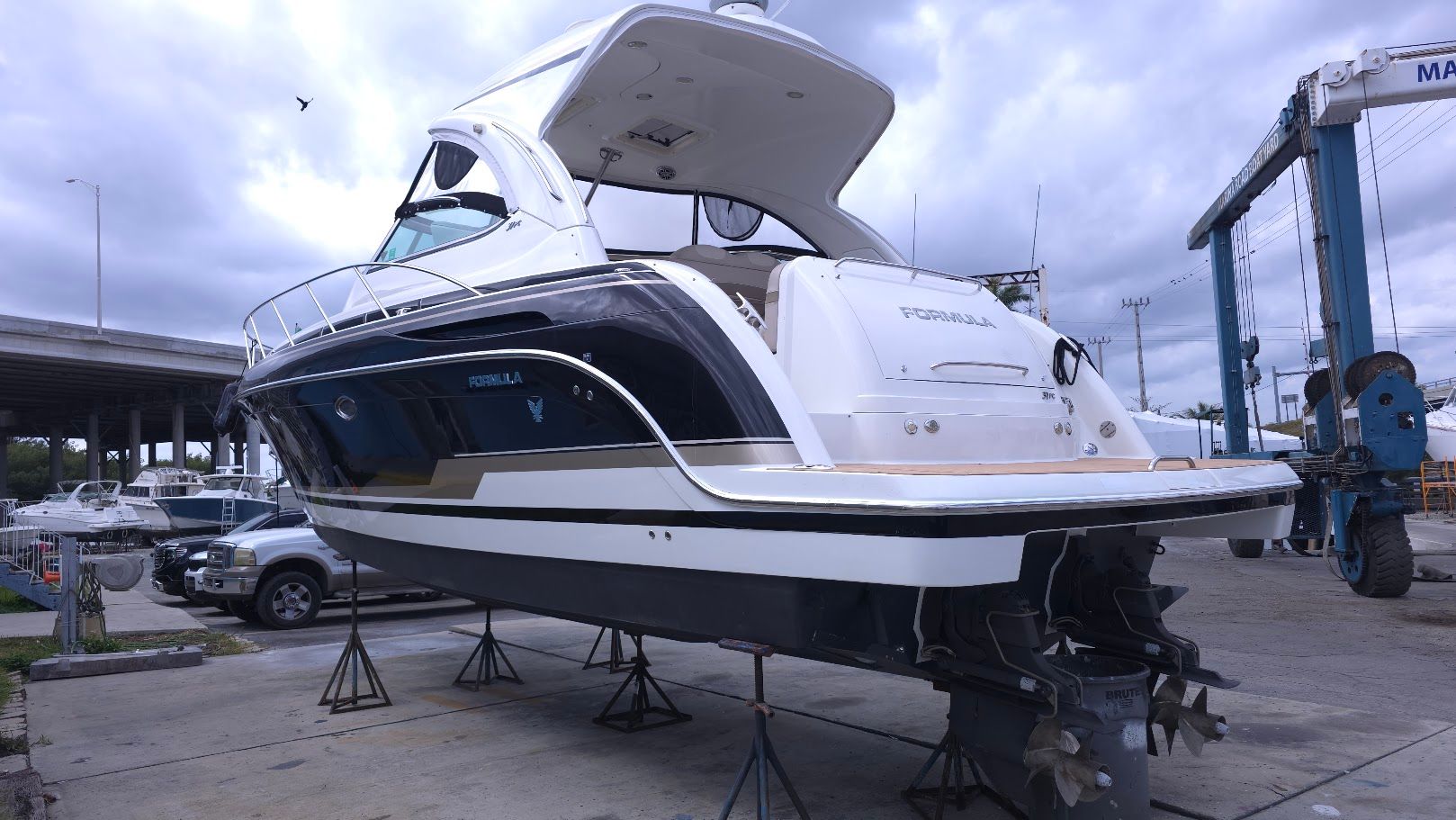 A 2016 Formula 37 Performance Cruiser is on a dry dock under a cloudy sky.