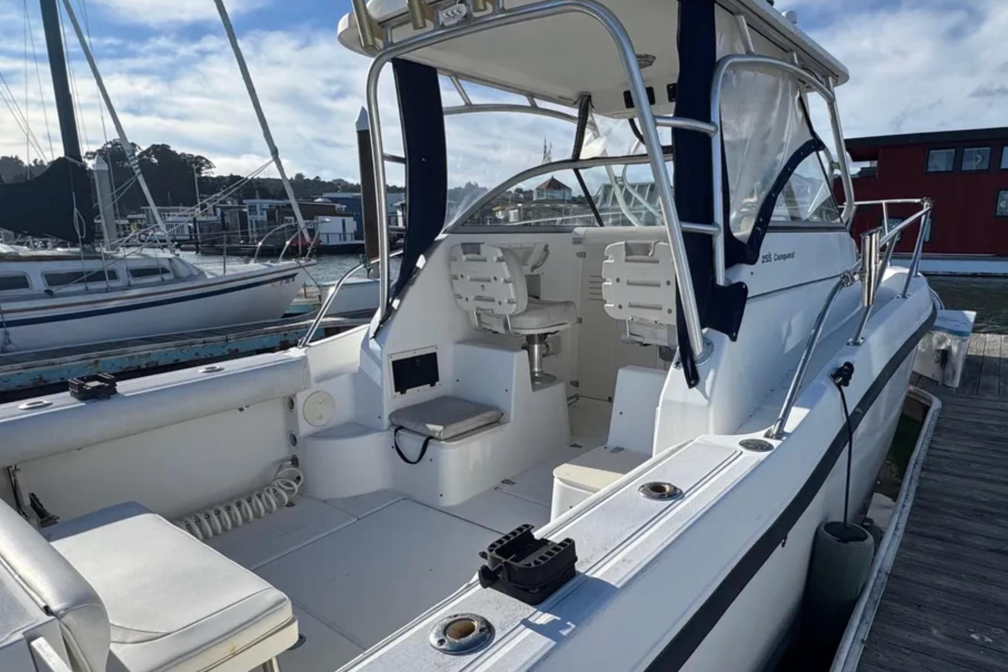 2004 Boston Whaler 255 Conquest boat docked, showcasing spacious cockpit and seating.