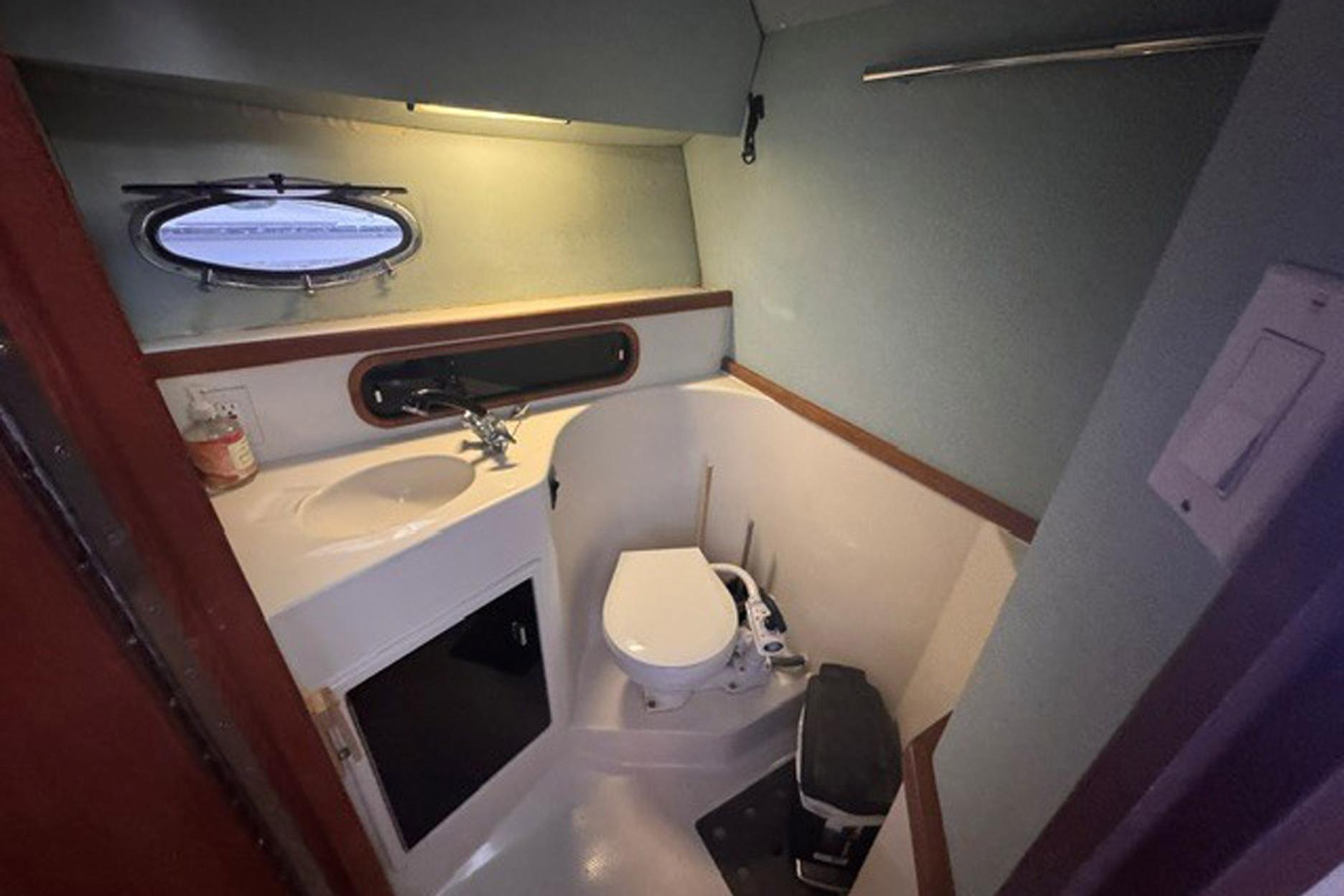Bathroom interior of 1988 Tiara Yachts 3300 Open, featuring sink and toilet.