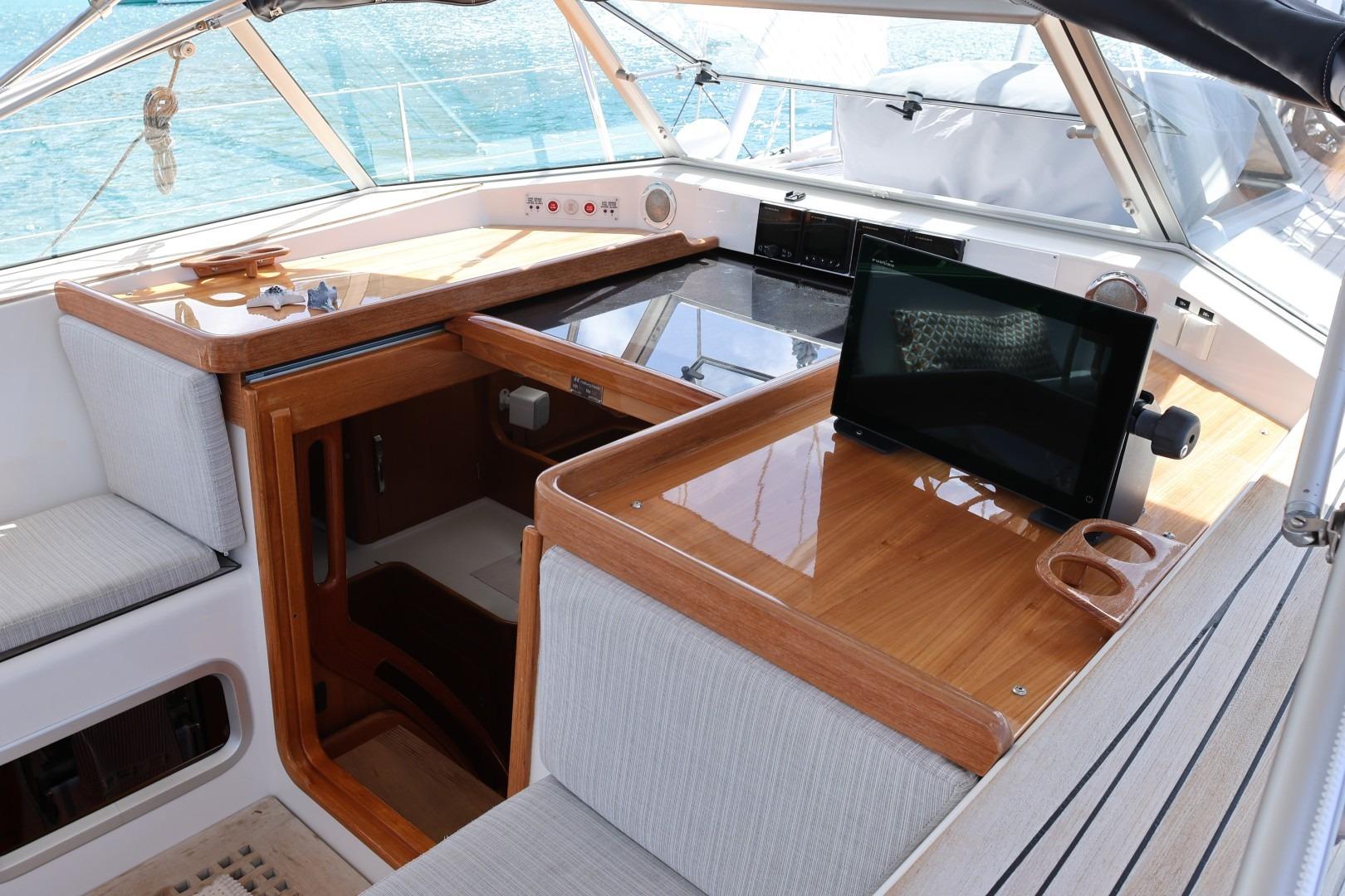 2009 Hallberg-Rassy 54 yacht interior with navigation station and seating area.