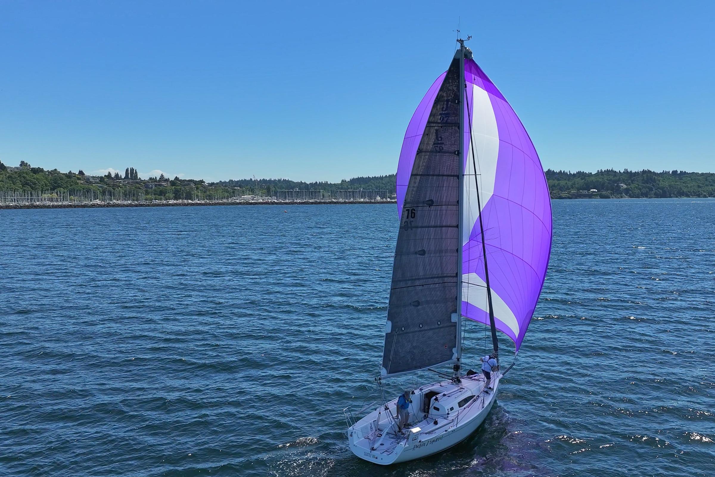 2018 J Boats J/97E sailing with vibrant purple spinnaker on a sunny day.