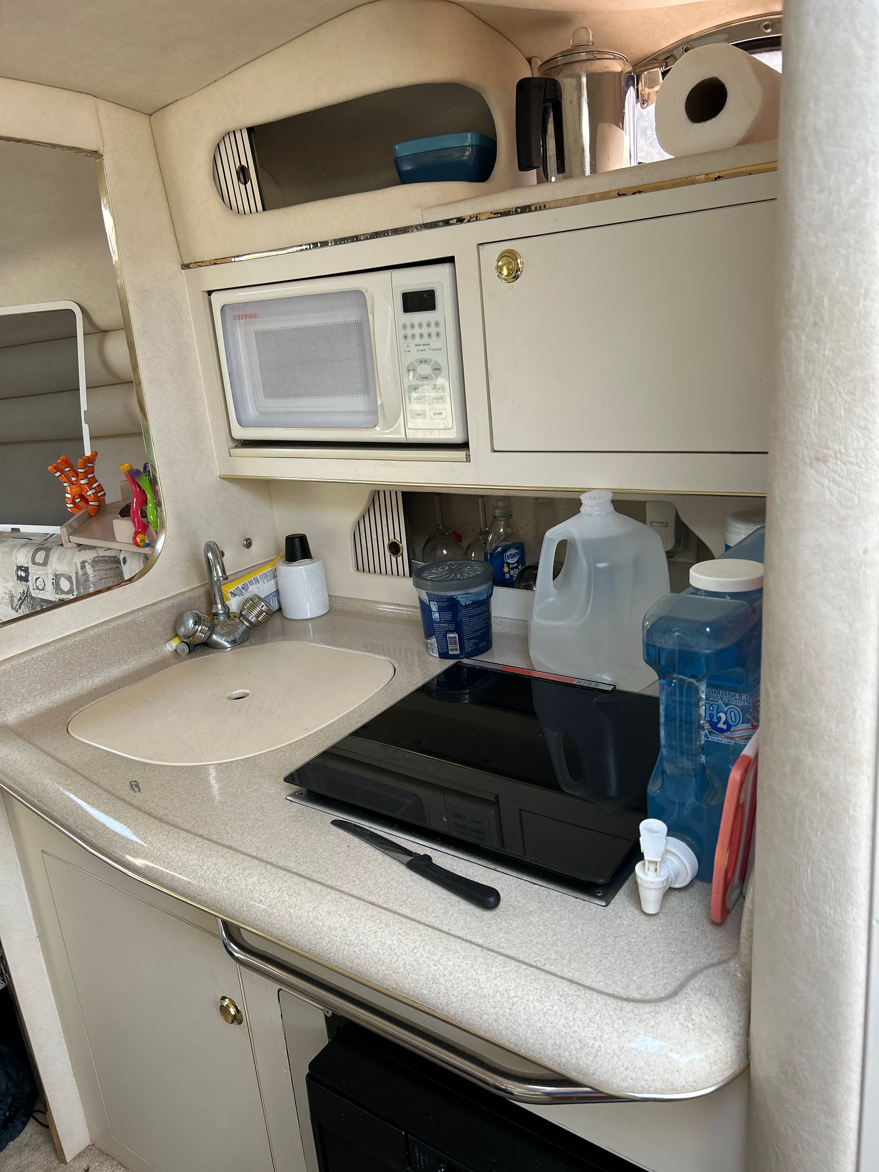 Galley area of a 1999 Sea Ray 270 Sundancer Special Edition with sink, microwave, and storage.