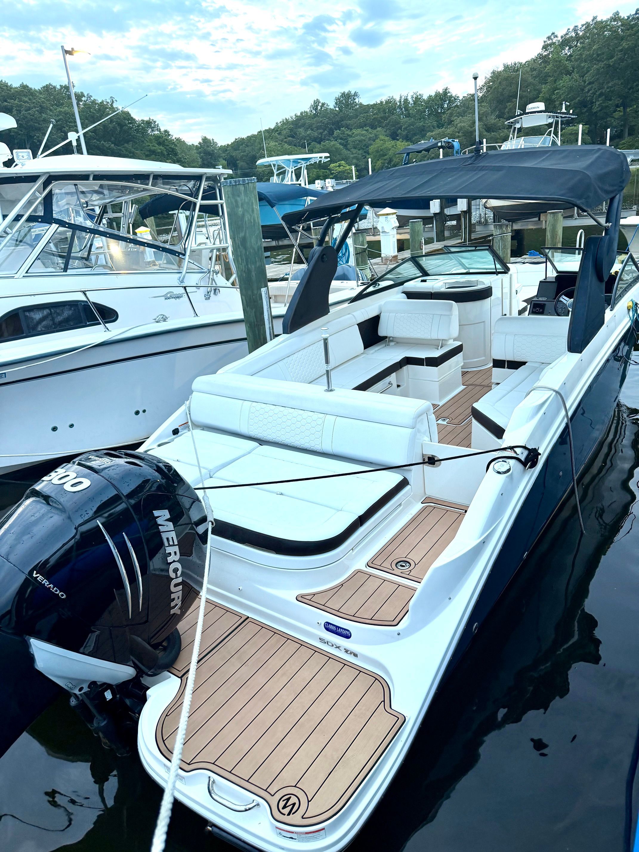 A 2018 Sea Ray SDX 270 Outboard is docked. It features sleek design with white seating and a Mercury engine.