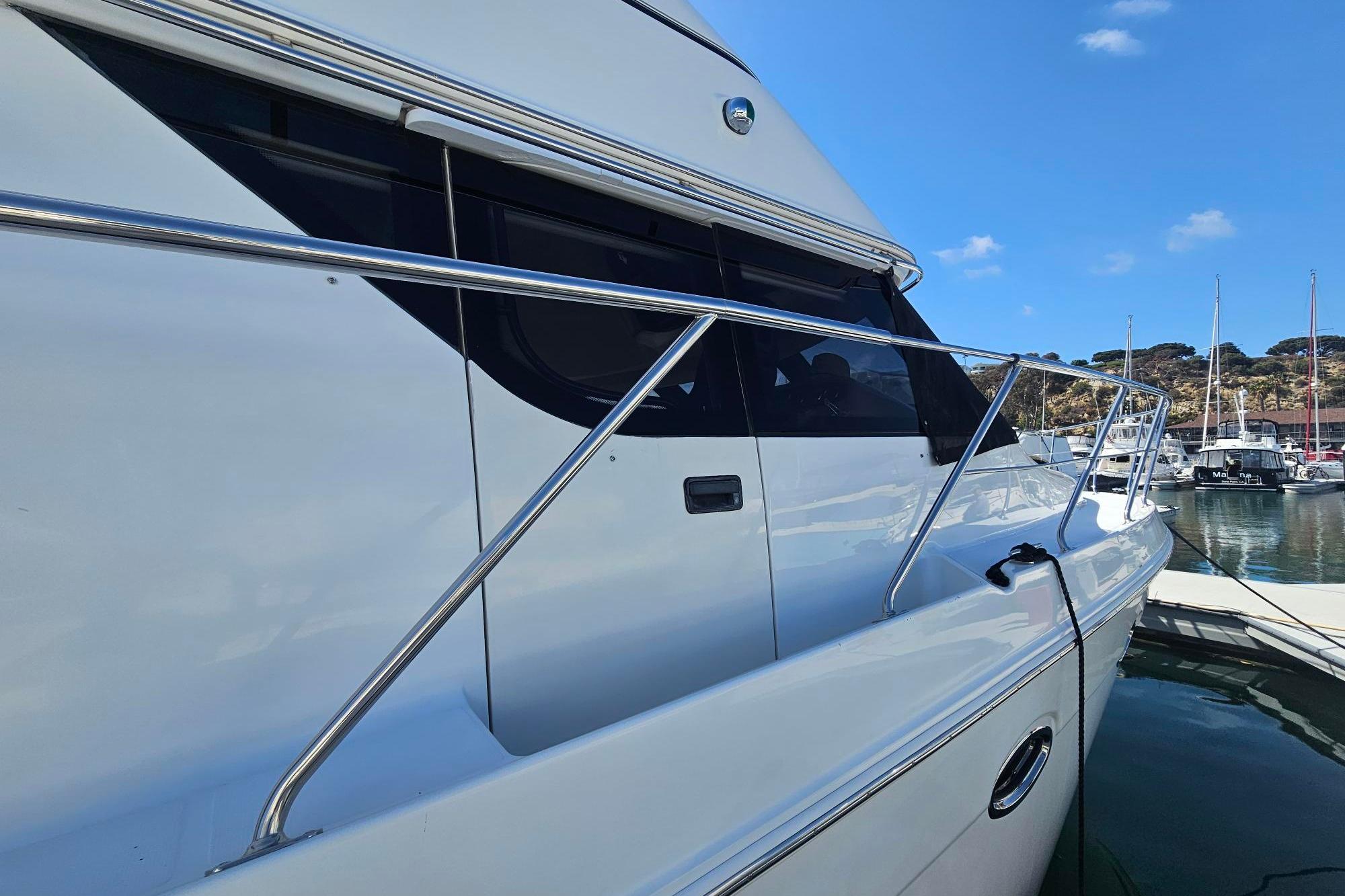 2002 Carver 450 Voyager Pilothouse yacht docked in a marina under a clear blue sky.