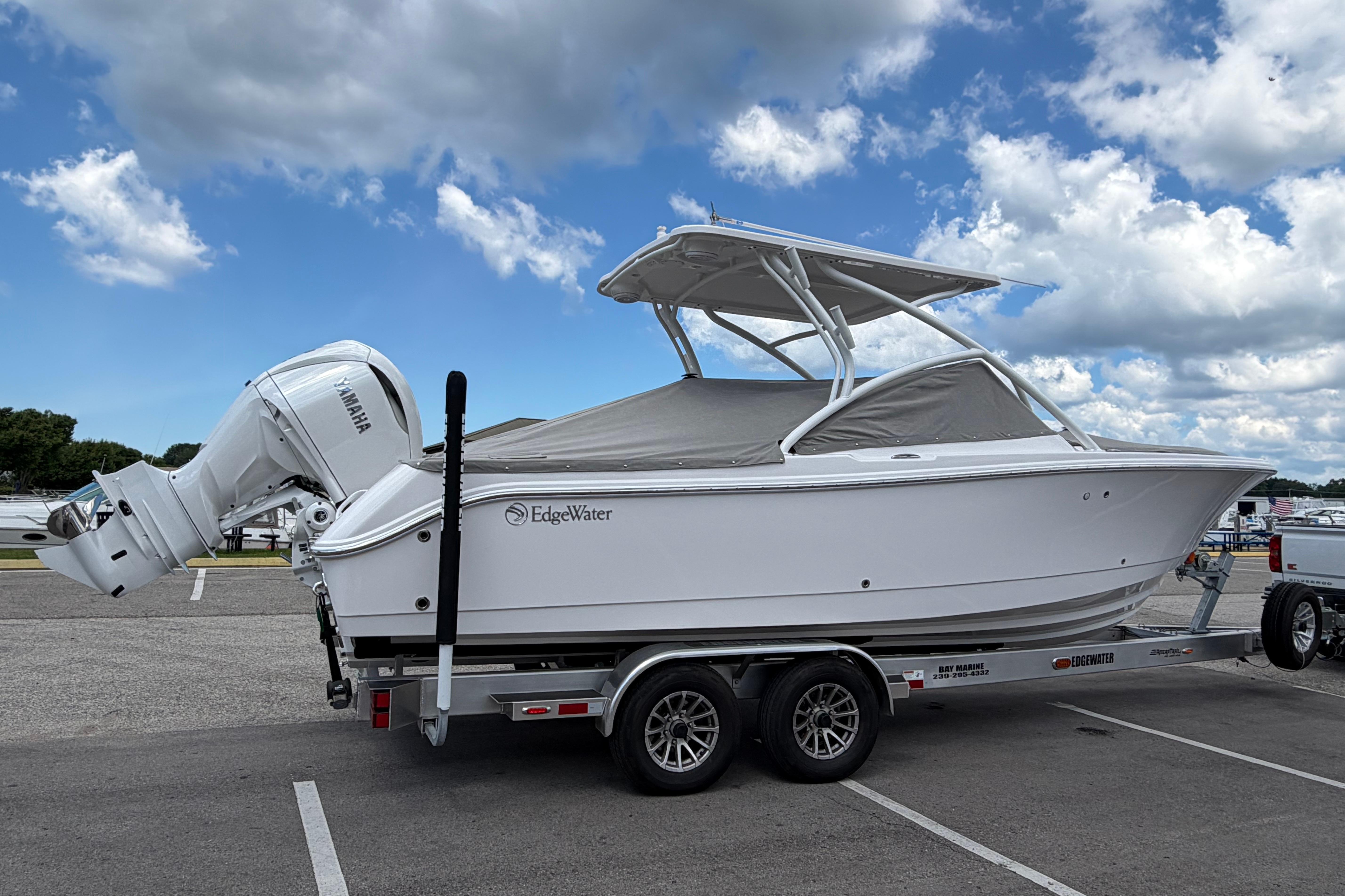 2026 Edgewater 248CX Crossover boat on trailer, featuring Yamaha outboard motor, under blue sky.