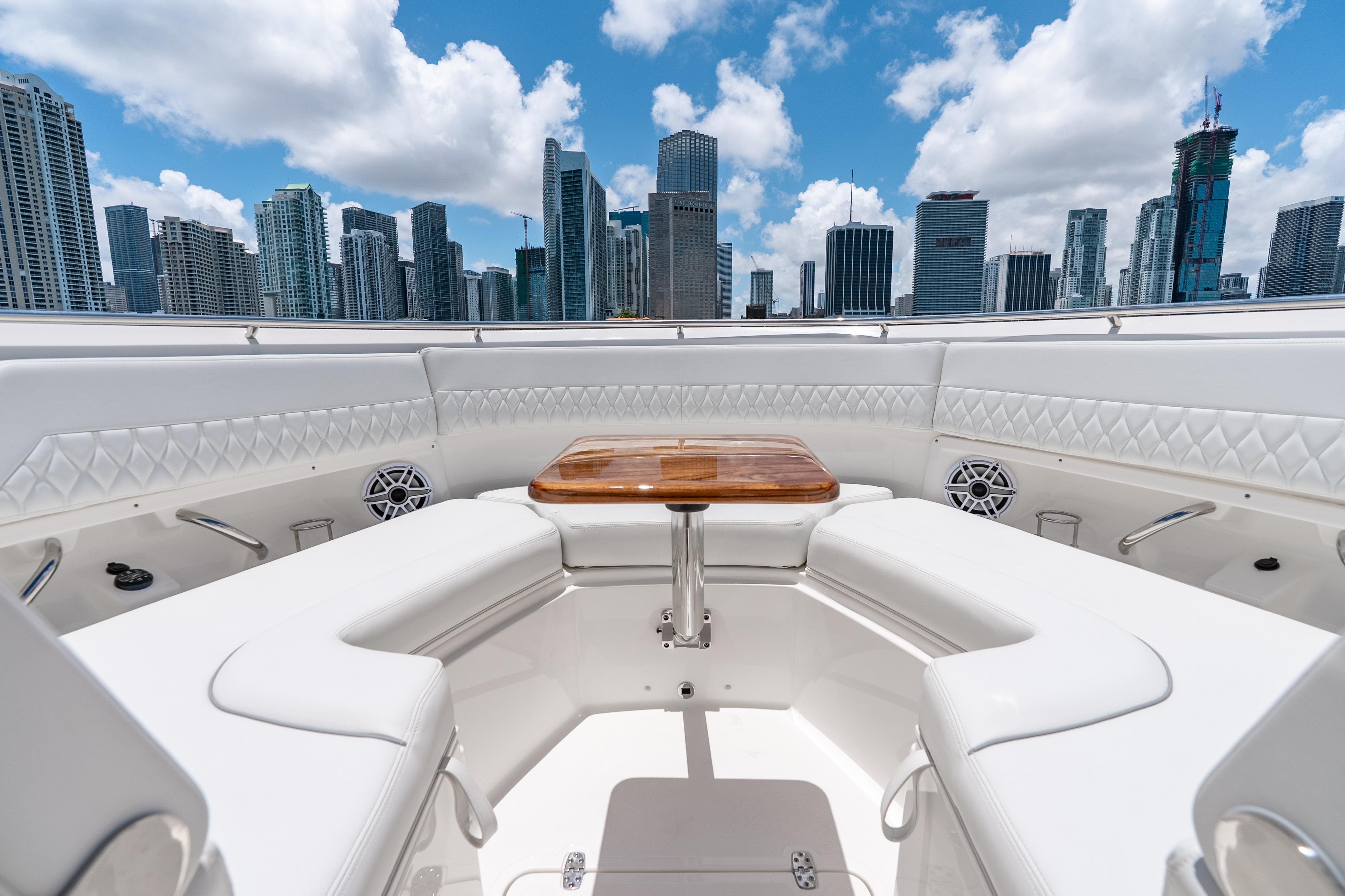Luxurious 2026 Pursuit DC 326 Dual Console boat interior with city skyline backdrop.