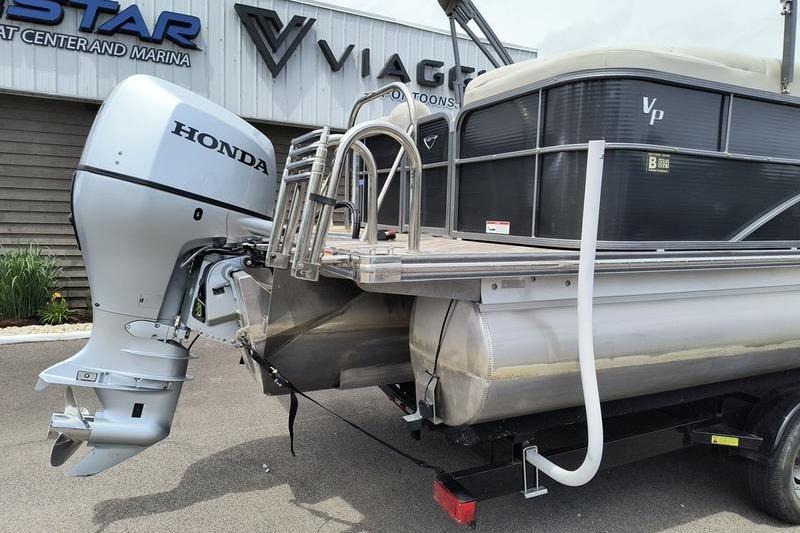2017 Manitou 25 Oasis SE pontoon boat with Honda outboard motor at marina.