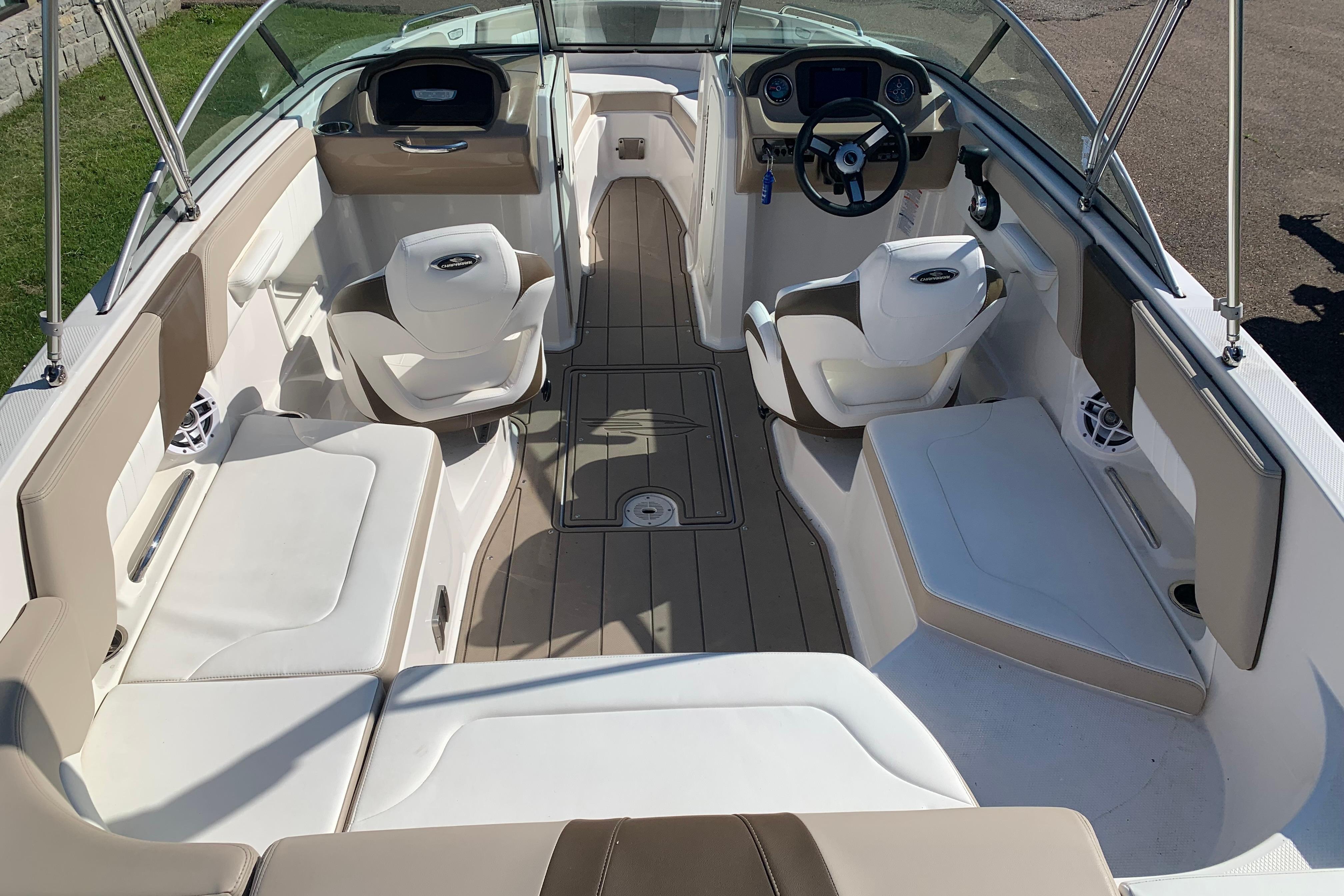 2022 Chaparral 23 SSi boat interior with beige and white seating, steering wheel, and dashboard.