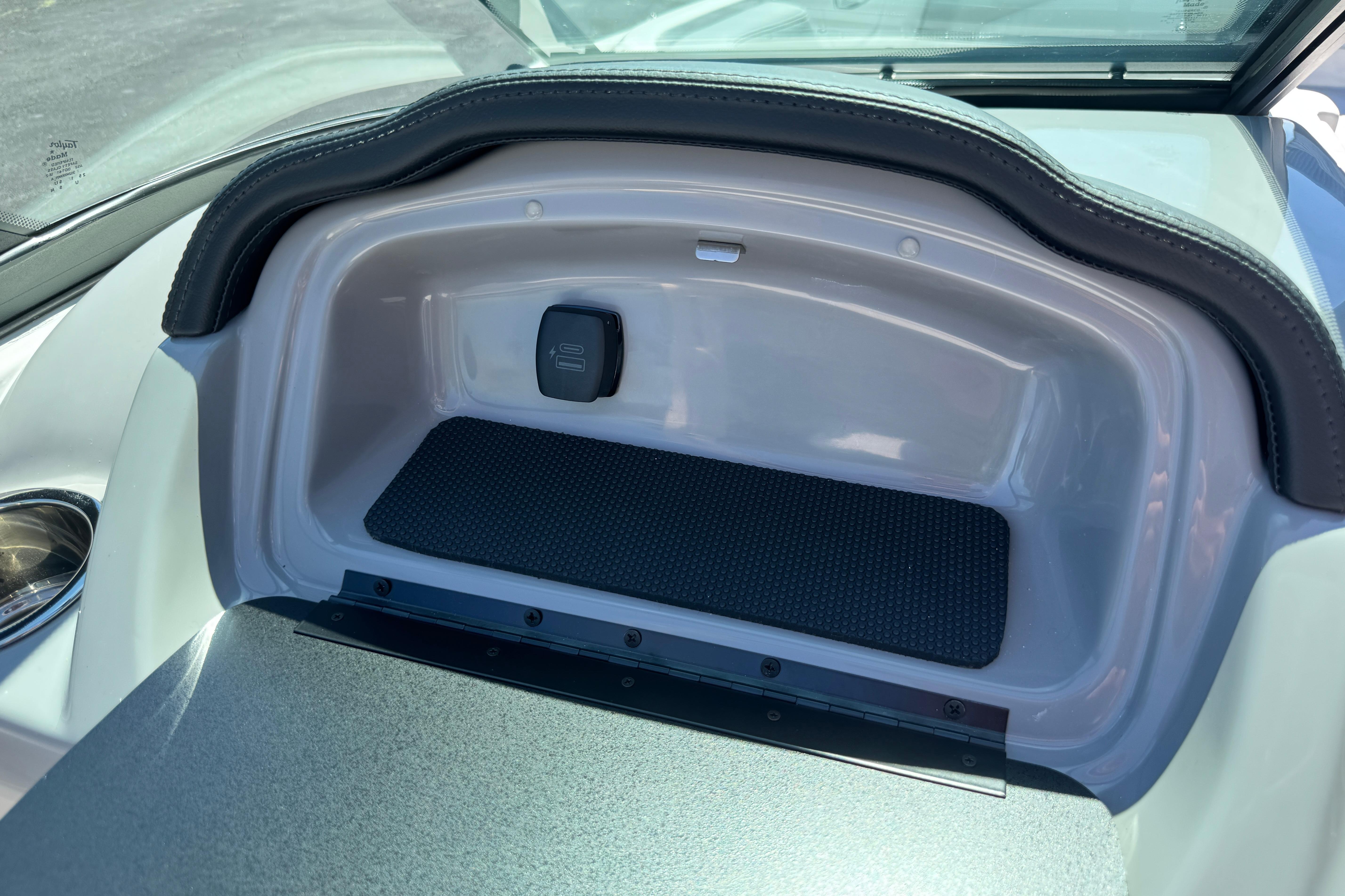 Storage compartment in 2026 Chaparral 21 SSi boat, featuring sleek design and USB port.