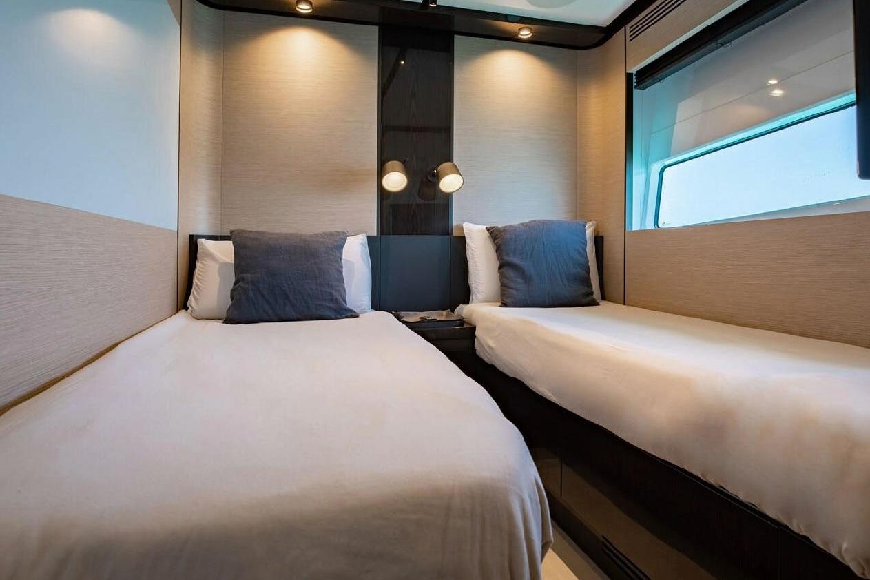 Luxurious twin cabin interior on 2022 Azimut S10 yacht, featuring modern design and cozy bedding.