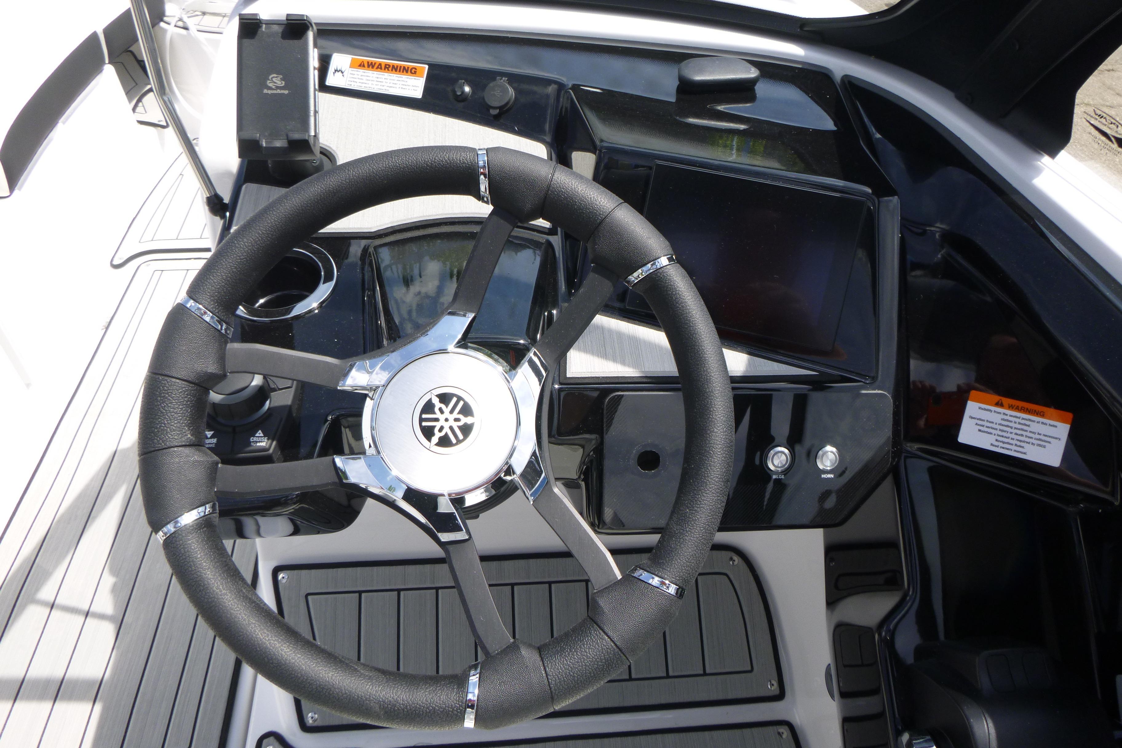 Steering wheel and dashboard of 2026 Yamaha Boats 222S, featuring modern controls and sleek design.