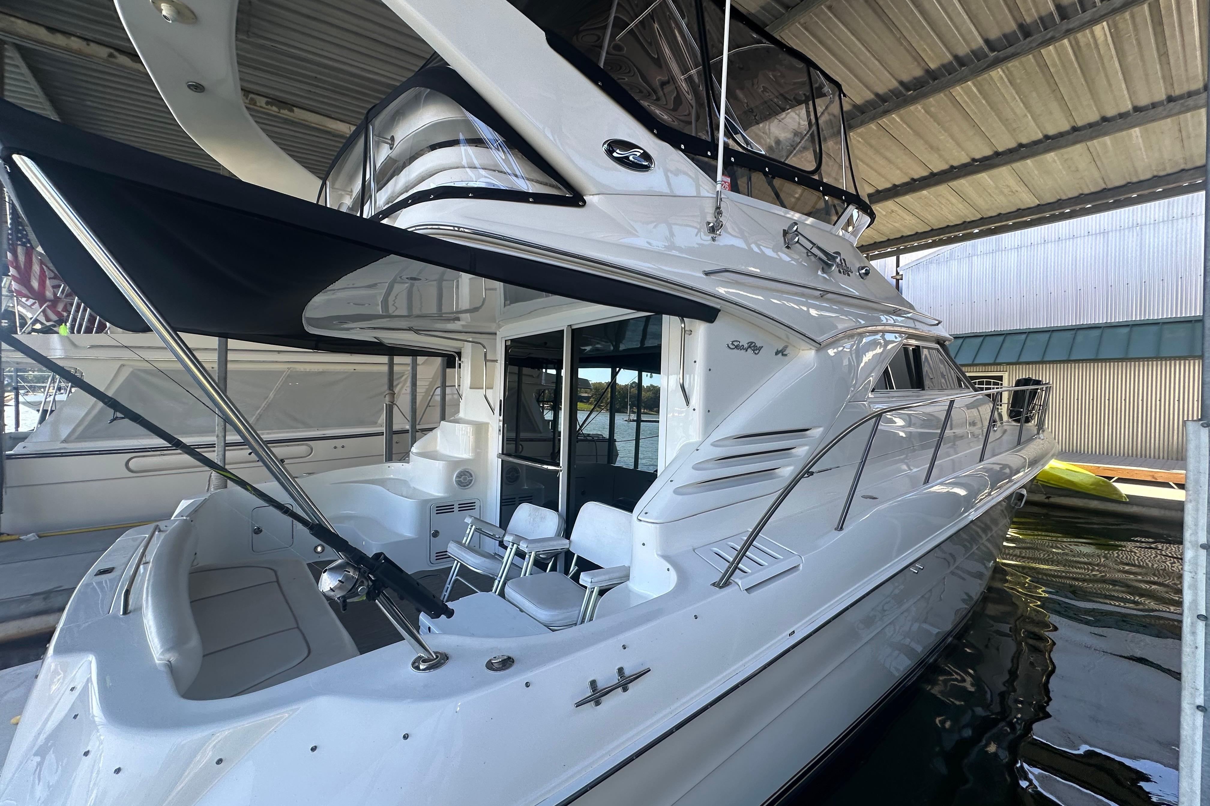 2000 Sea Ray 400 Sedan Bridge yacht docked under a covered marina.