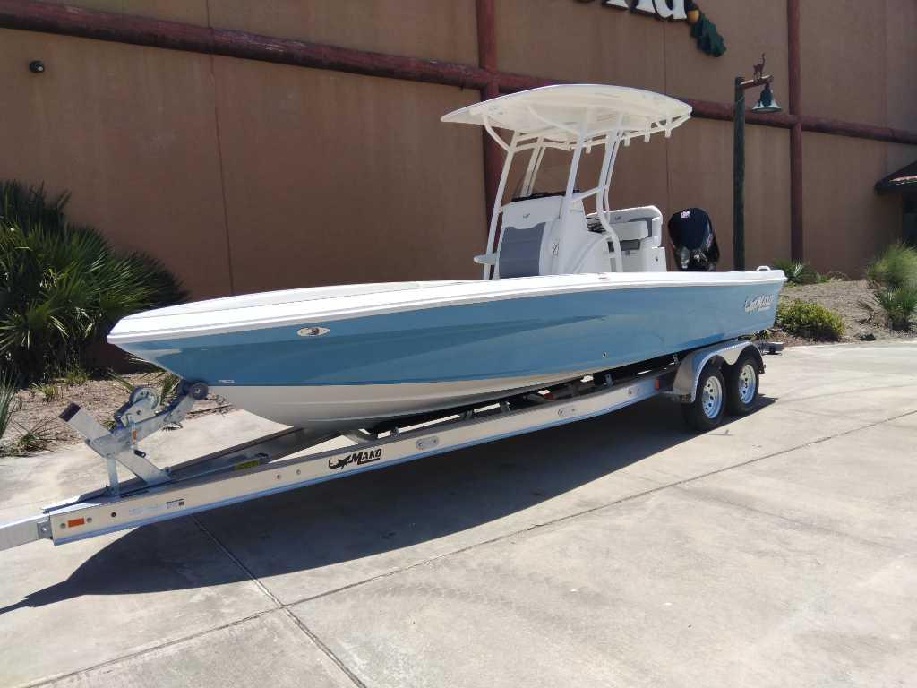 2025 Mako 24 APEX boat on trailer, blue hull, parked outdoors.