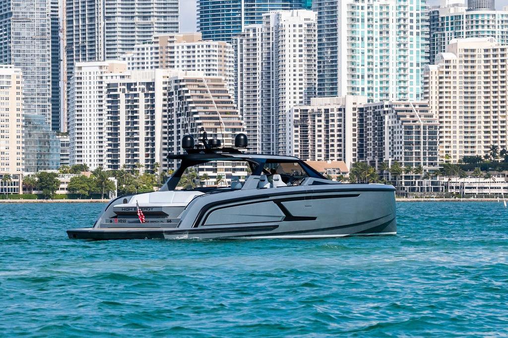 2024 Vanquish Yachts VQ55 cruising near city skyline on blue water.