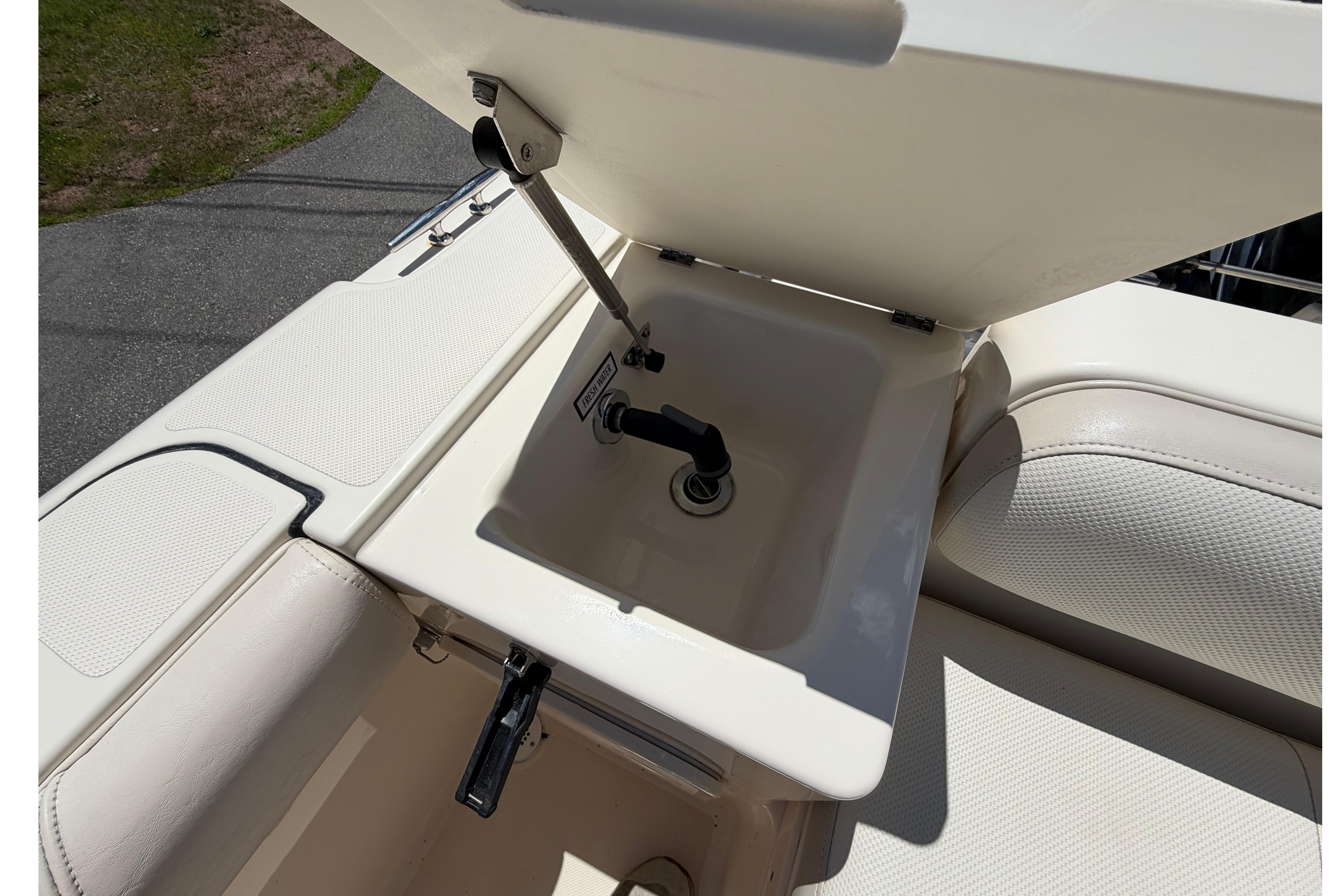 2010 Pursuit OS 255 Offshore boat sink with open lid, showcasing compact design.
