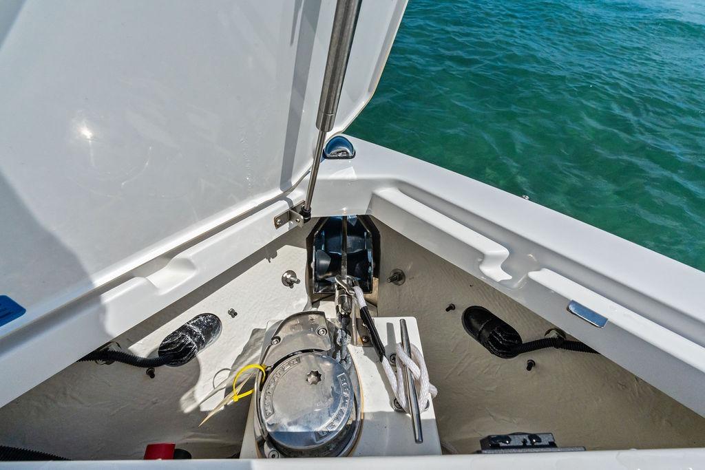 2022 Cobalt R8 Outboard boat anchor compartment with open hatch, near water.