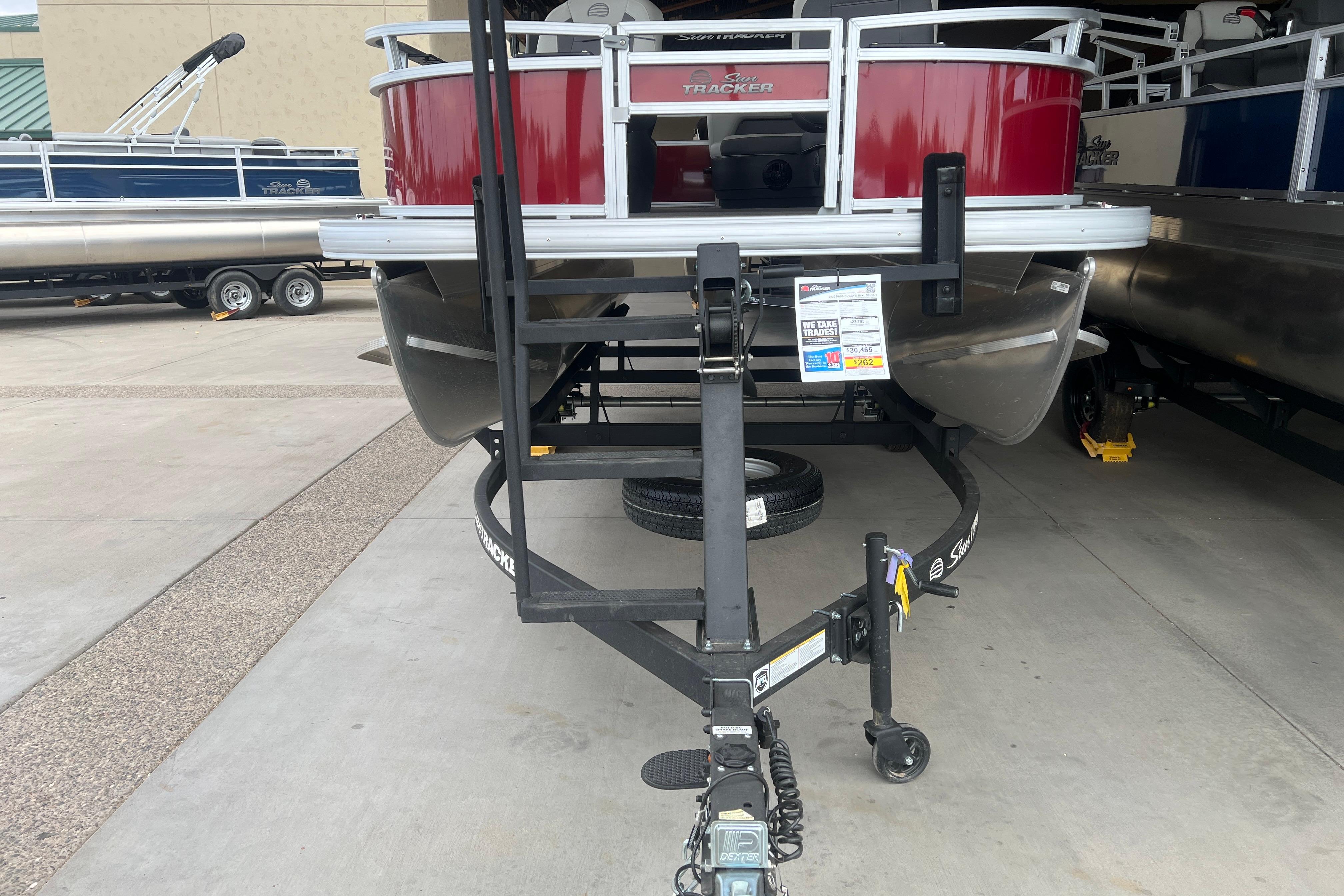 2026 Sun Tracker Bass Buggy 16 XL Select pontoon boat on trailer, front view.