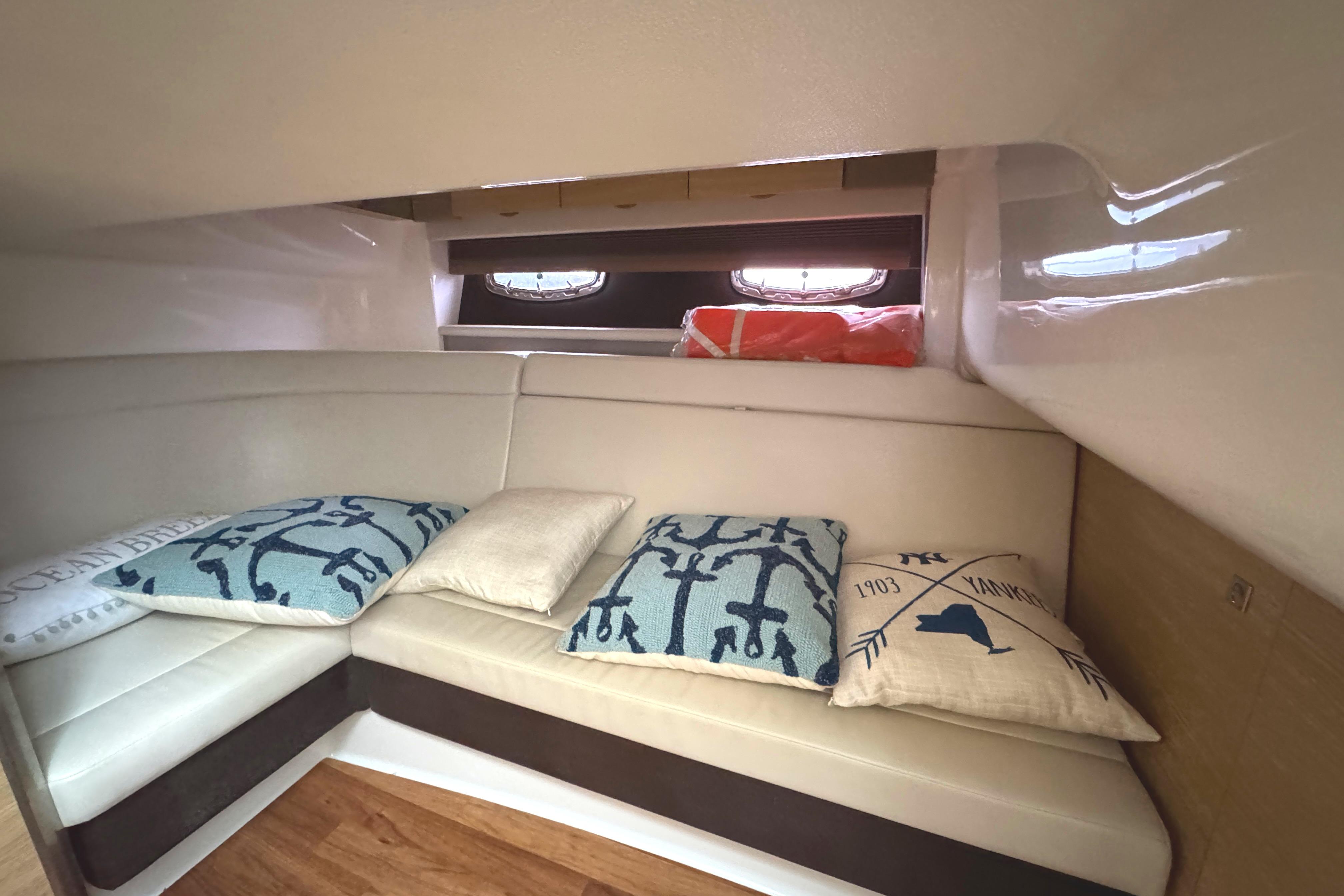 Interior of 2012 Chaparral 327 SSX boat with cozy seating and decorative pillows.