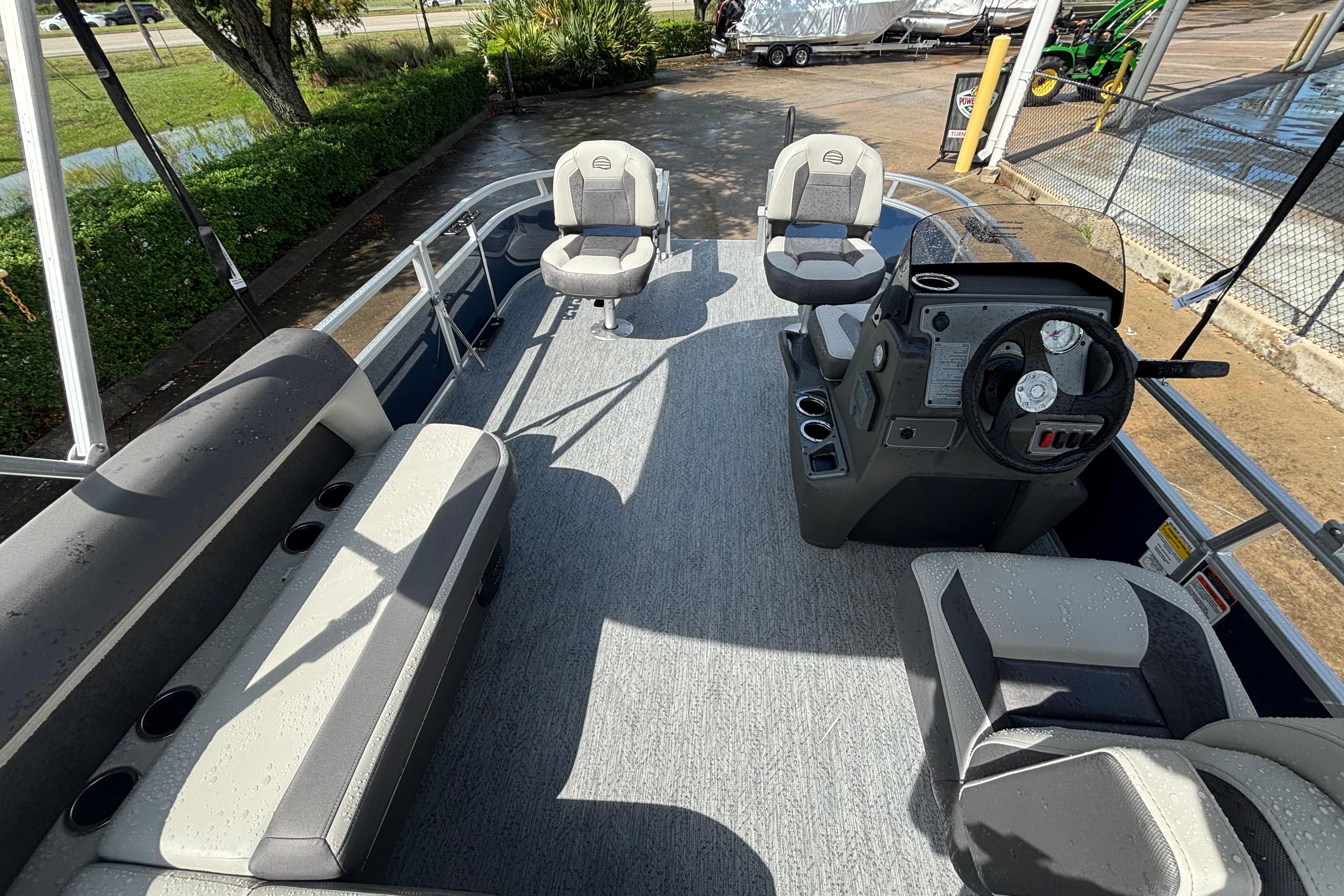 2026 Sun Tracker Bass Buggy 16 XL Select pontoon boat interior with seating and steering console.