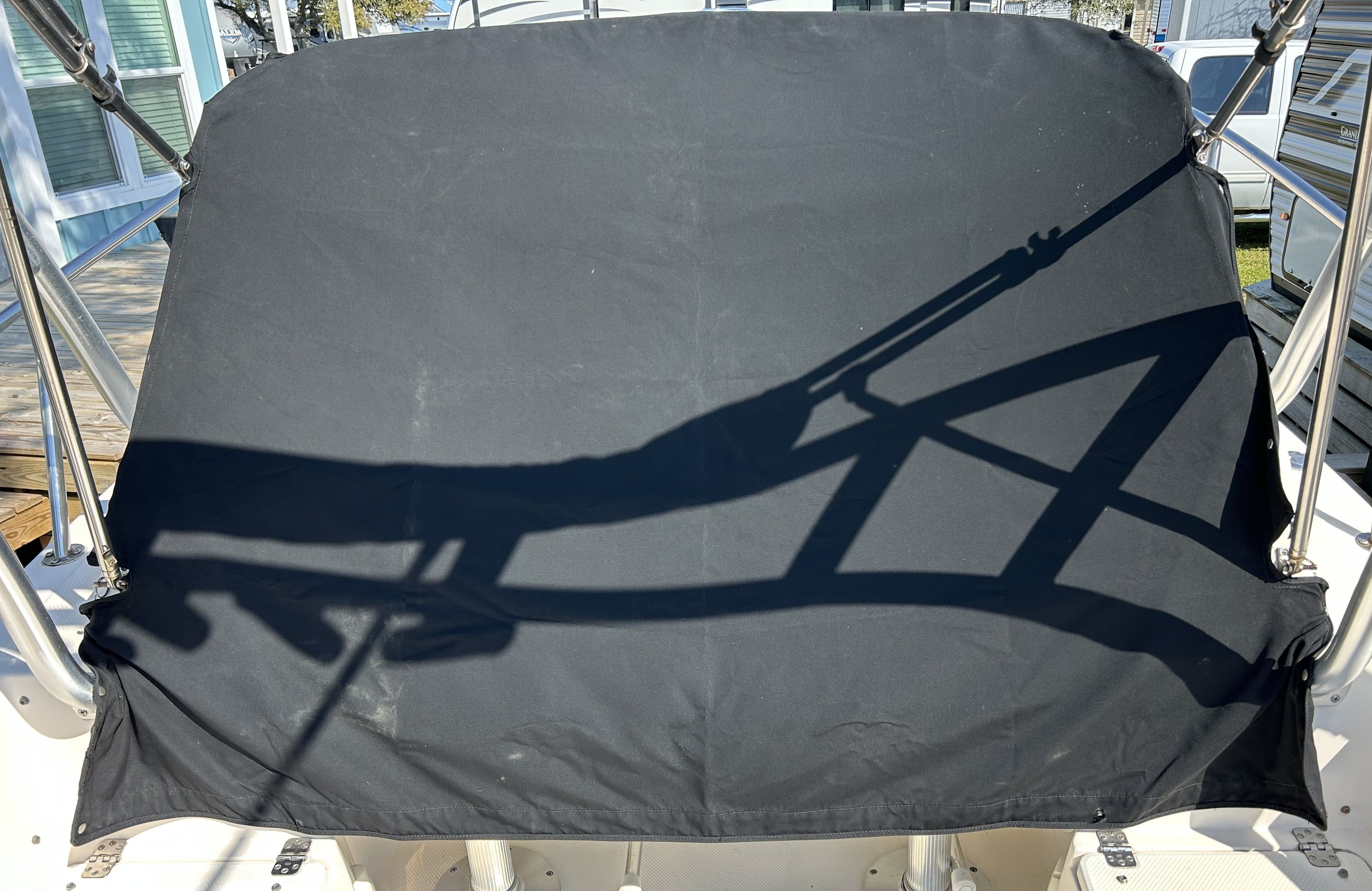 Shadow of a boat canopy on black fabric.