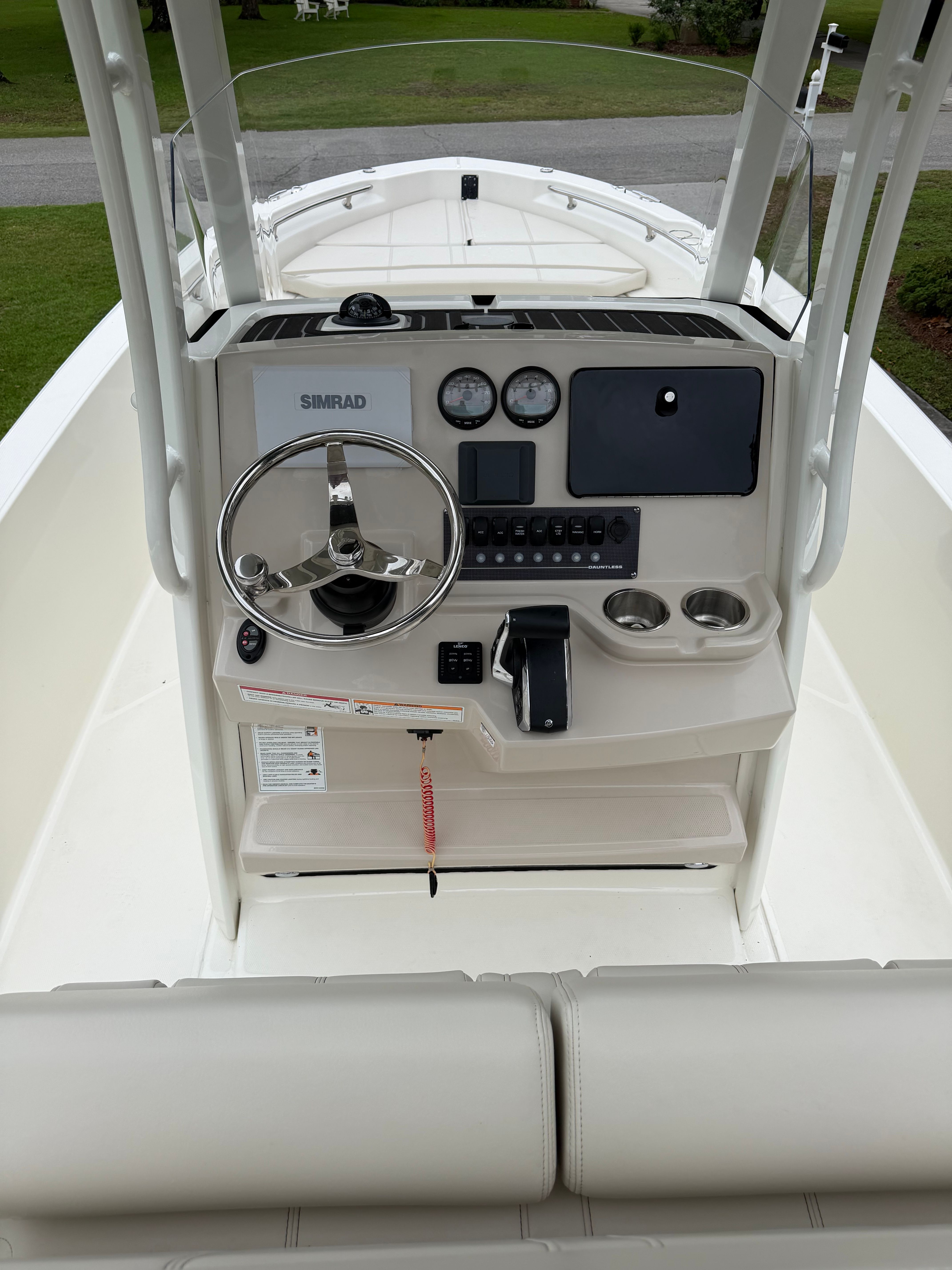The image shows the helm of a Boston Whaler 220 Dauntless boat with modern instruments.