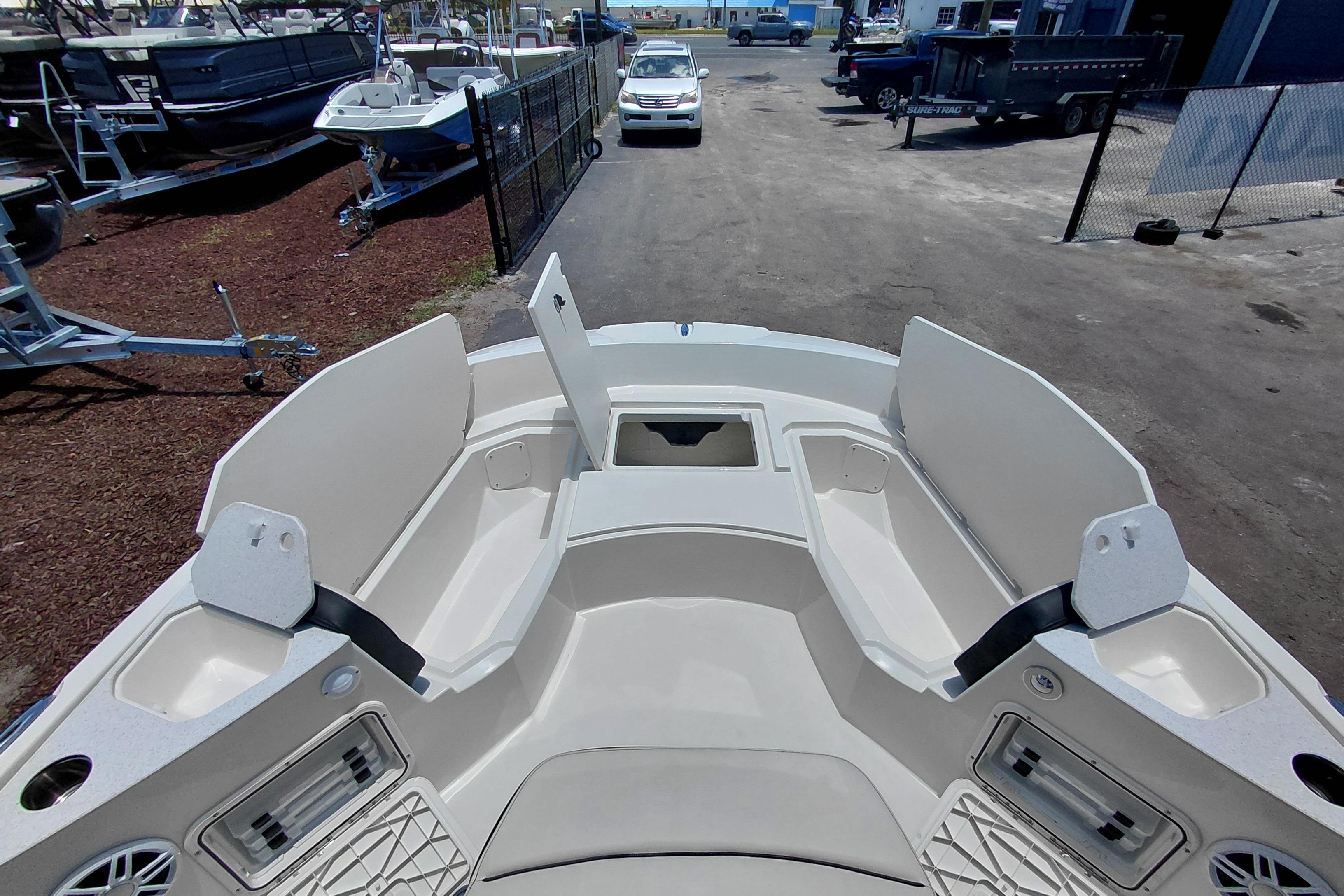 2023 Stingray 206 CC boat interior with open storage compartments, parked outdoors.