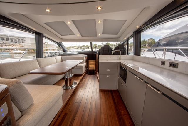 Luxurious interior of 2024 Princess V55 yacht with modern kitchen and seating area.
