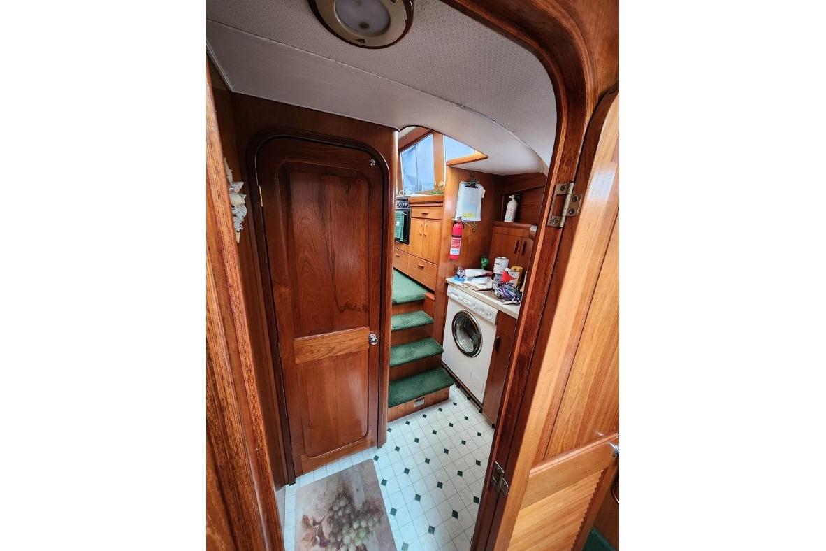Interior of 1984 Gulfstar 49 Motor Yacht with wooden finish and laundry area.