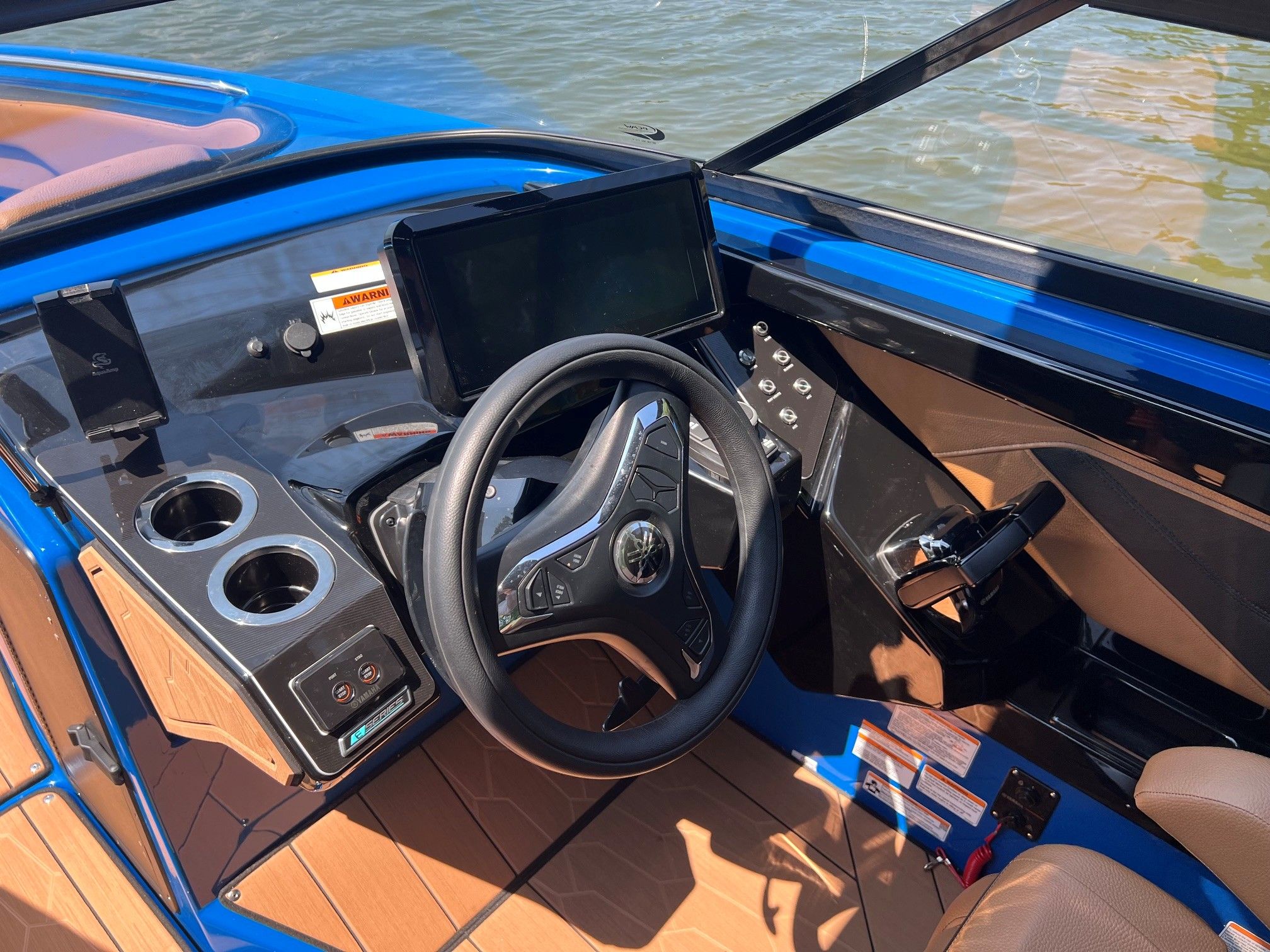 The image shows the cockpit of a 2026 Yamaha Boats 255XD with a modern steering wheel and touchscreen.