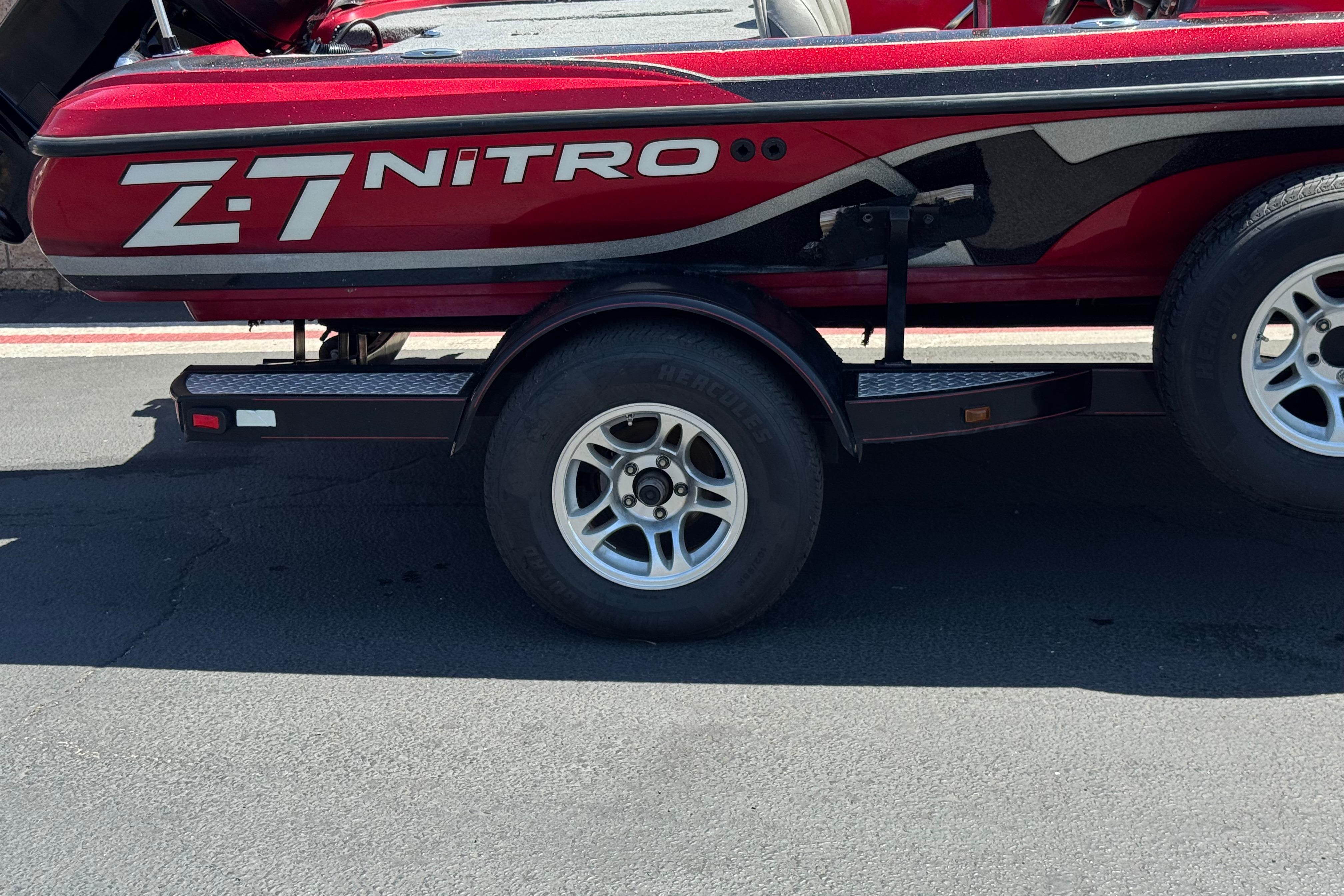 Red 2012 Nitro Z-7 boat on trailer, showcasing sleek design and branding.