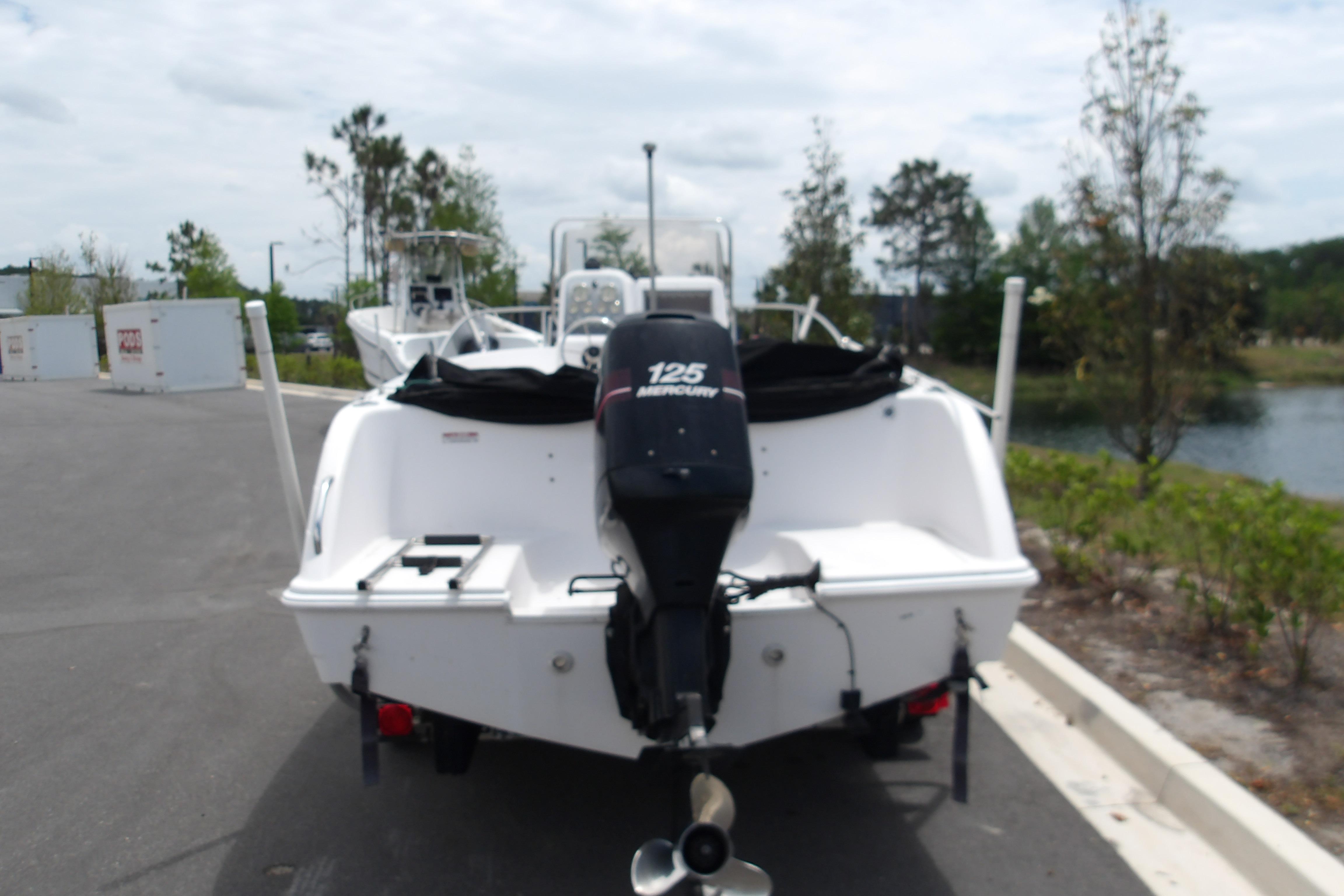 2000 Pro-Line 19 Sport boat with Mercury 125 outboard motor, parked near water.
