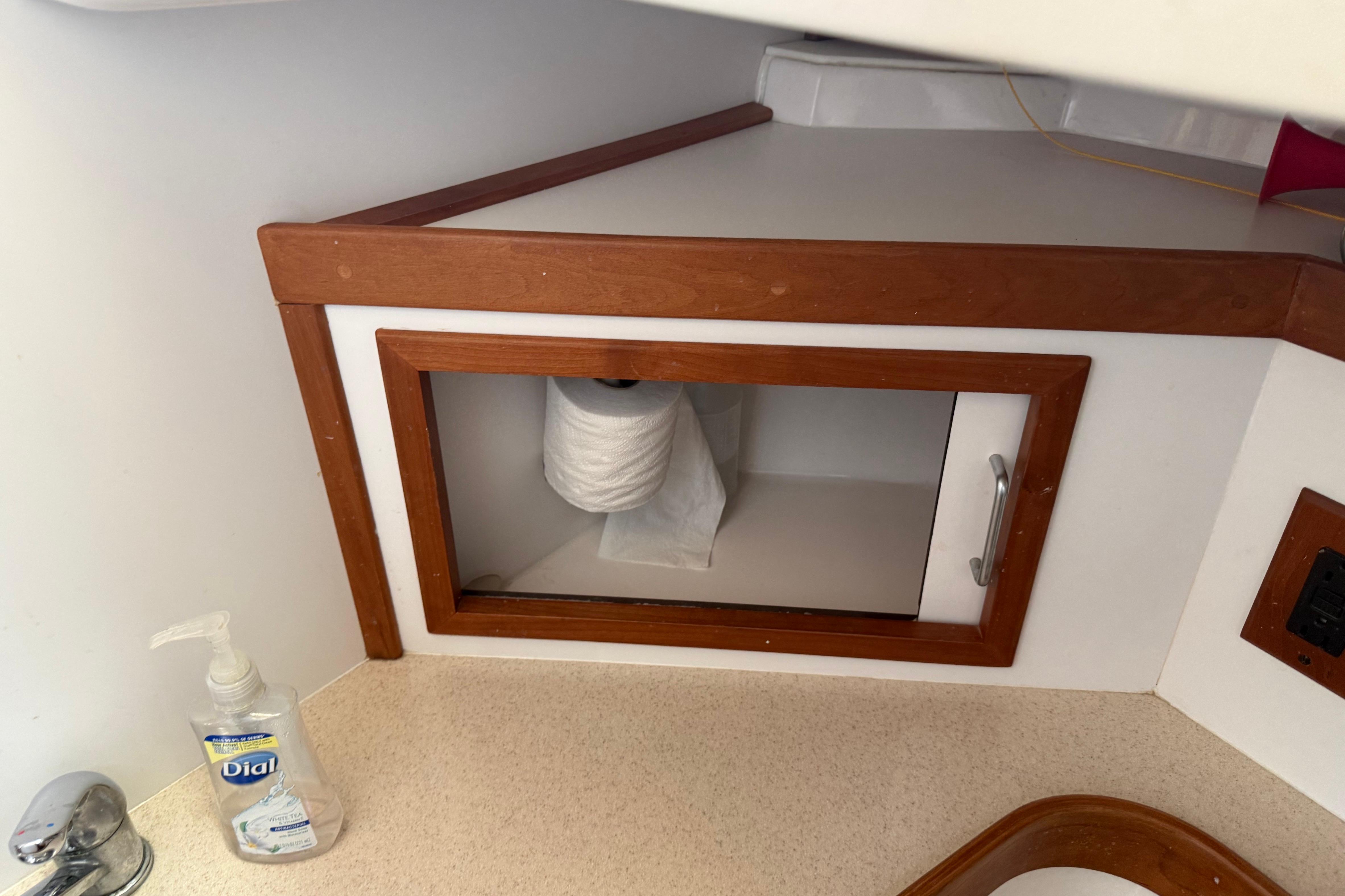 Cabinet with toilet paper and hand soap in a 2004 Sabre 386 boat.