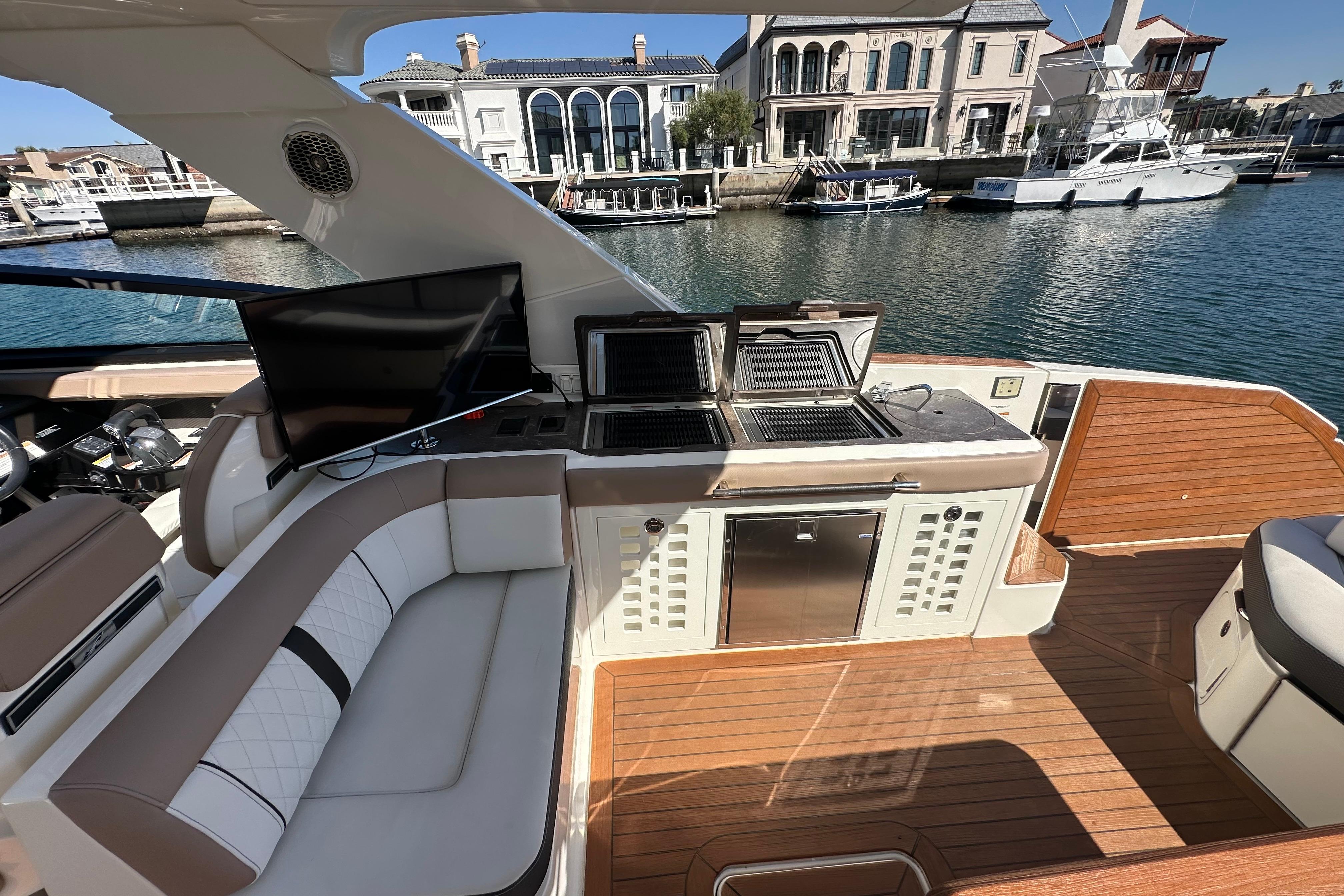 Luxurious 2018 Sea Ray SLX 400 yacht interior with seating, grill, and waterfront view.