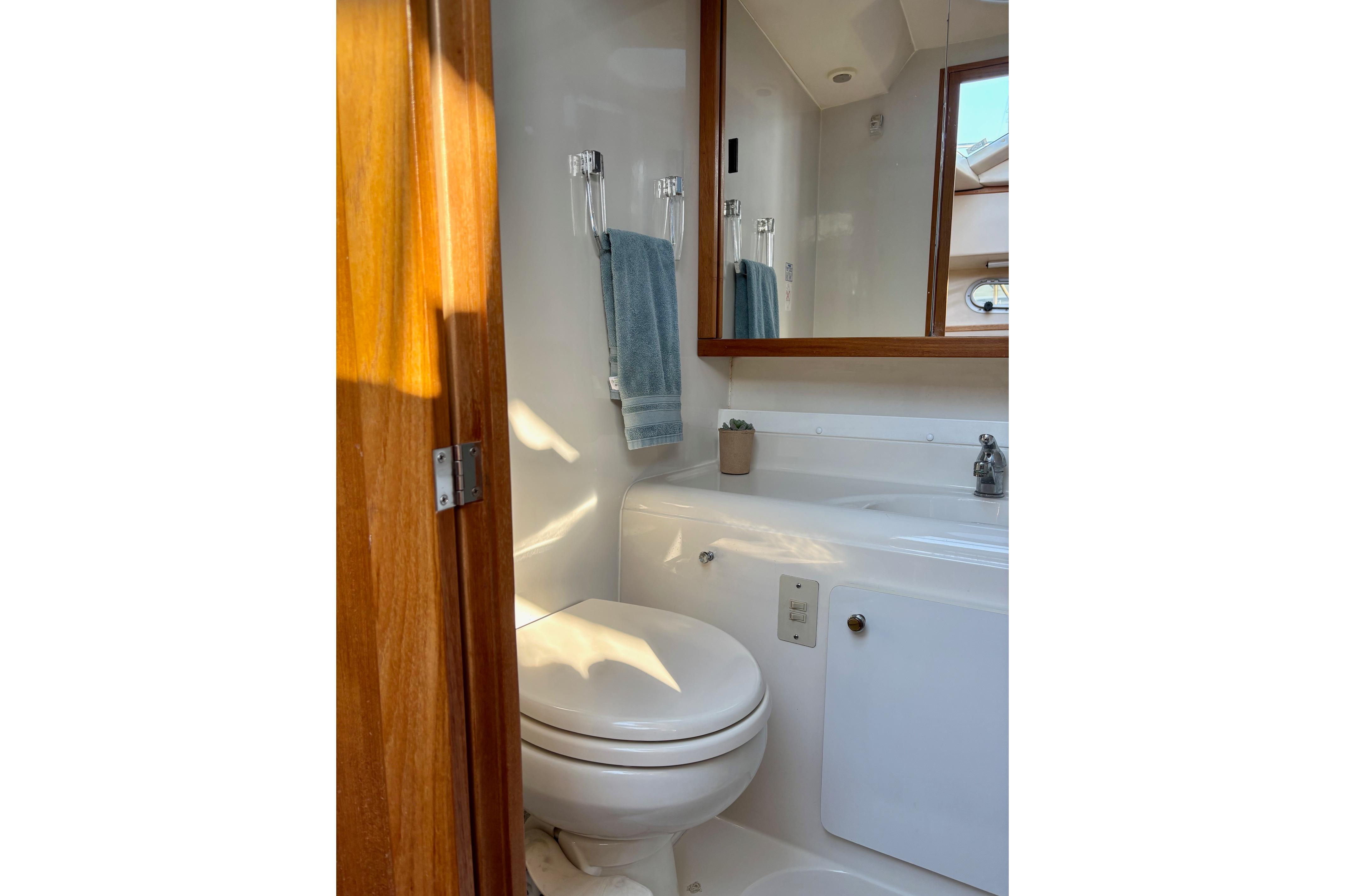 1998 Bayliner 3388 Command Bridge Motoryacht bathroom with toilet, sink, and mirror.