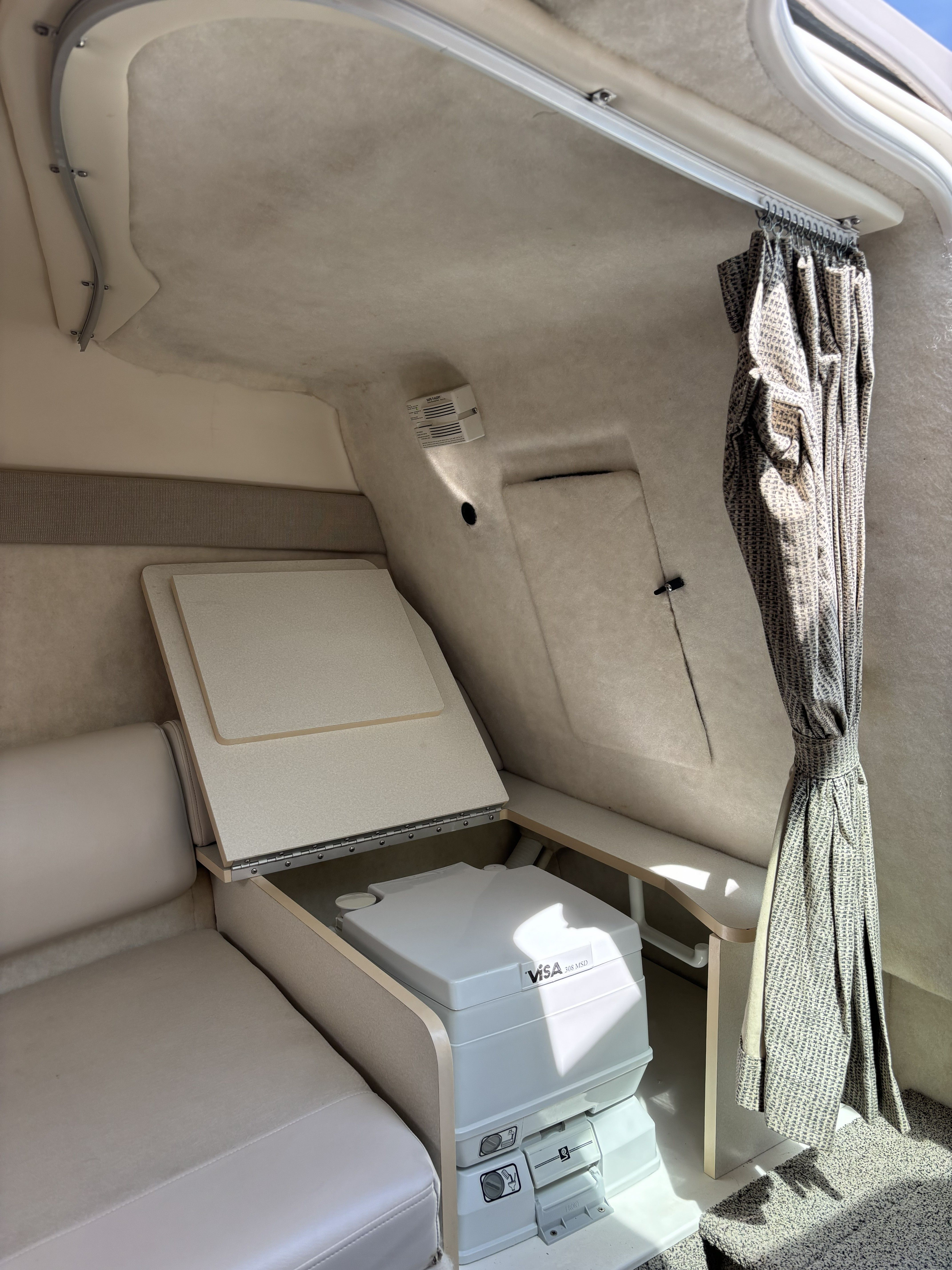Interior of 2005 Maxum 2400 SC3 boat with seating and curtain.