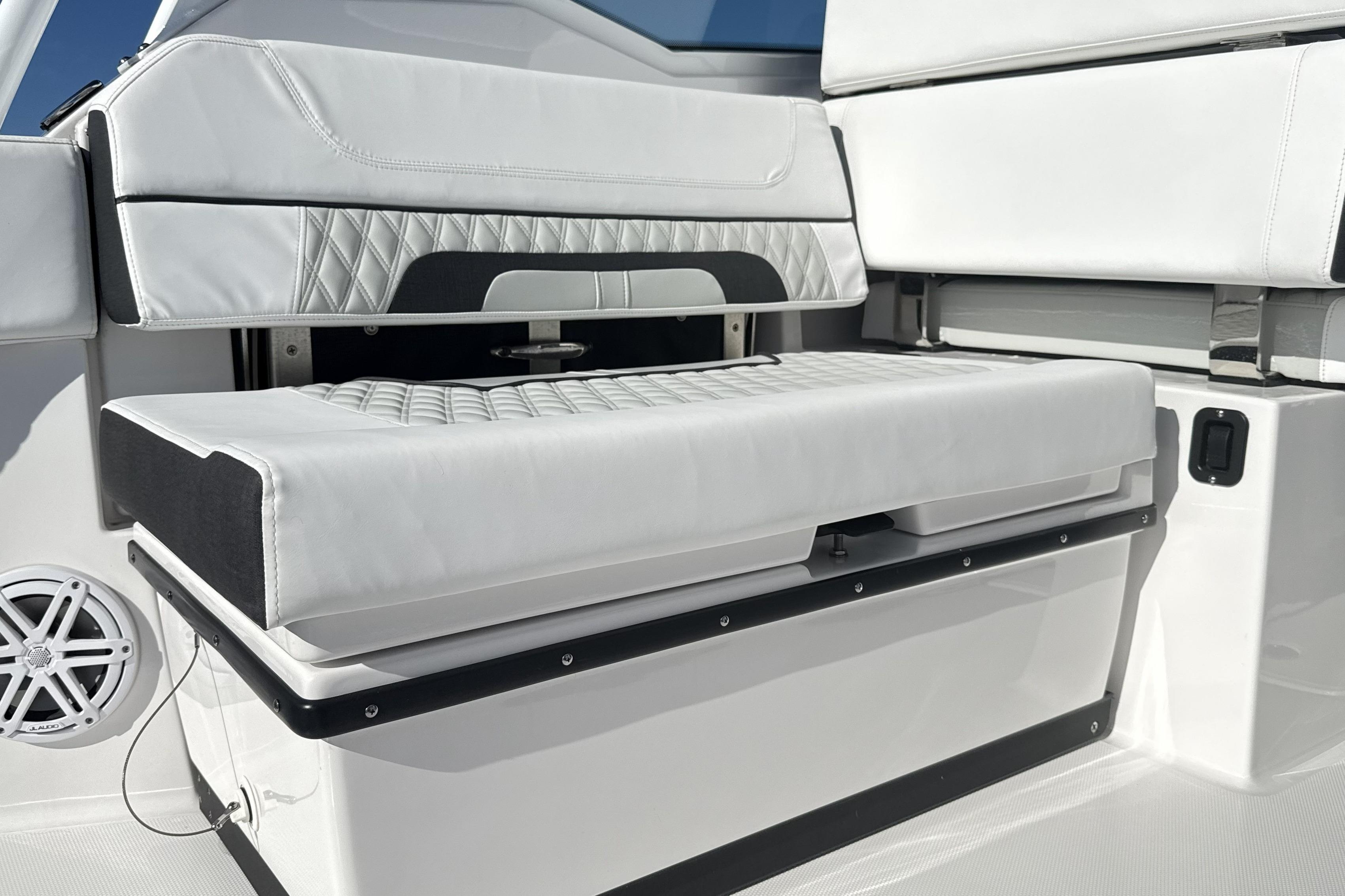 2025 Blackfin 272 DC boat interior with white cushioned seating and speaker.