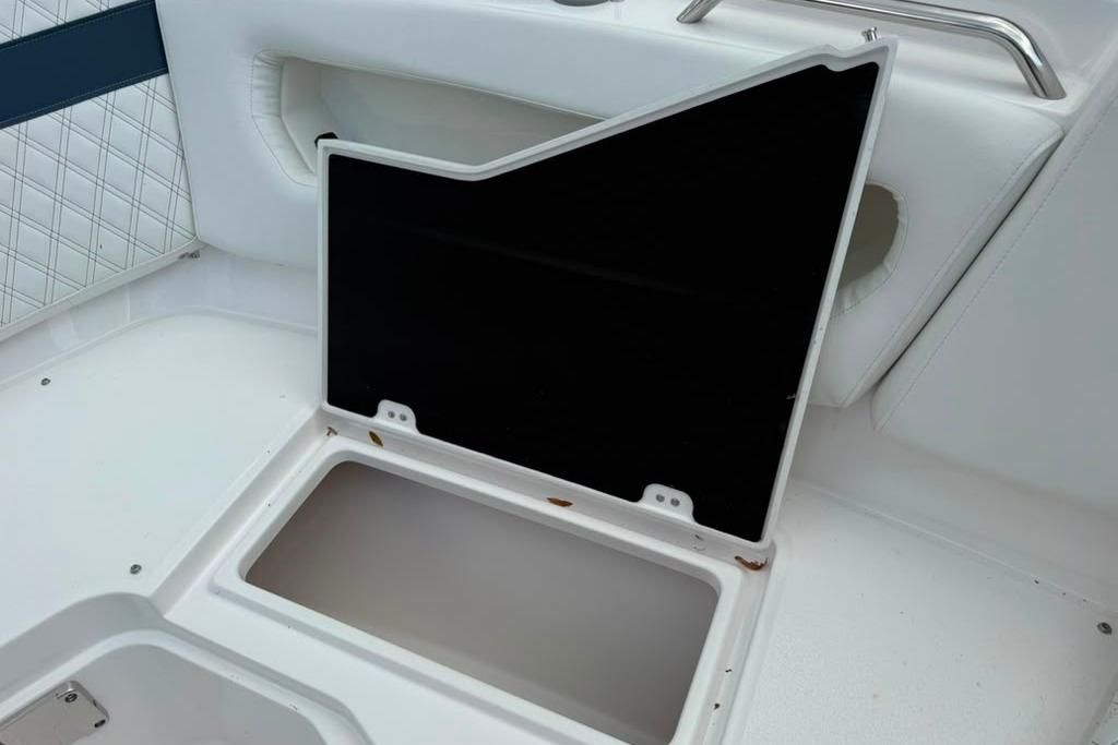 Open storage compartment on 2026 Sea Fox 288 Traveler boat, featuring white and blue interior.
