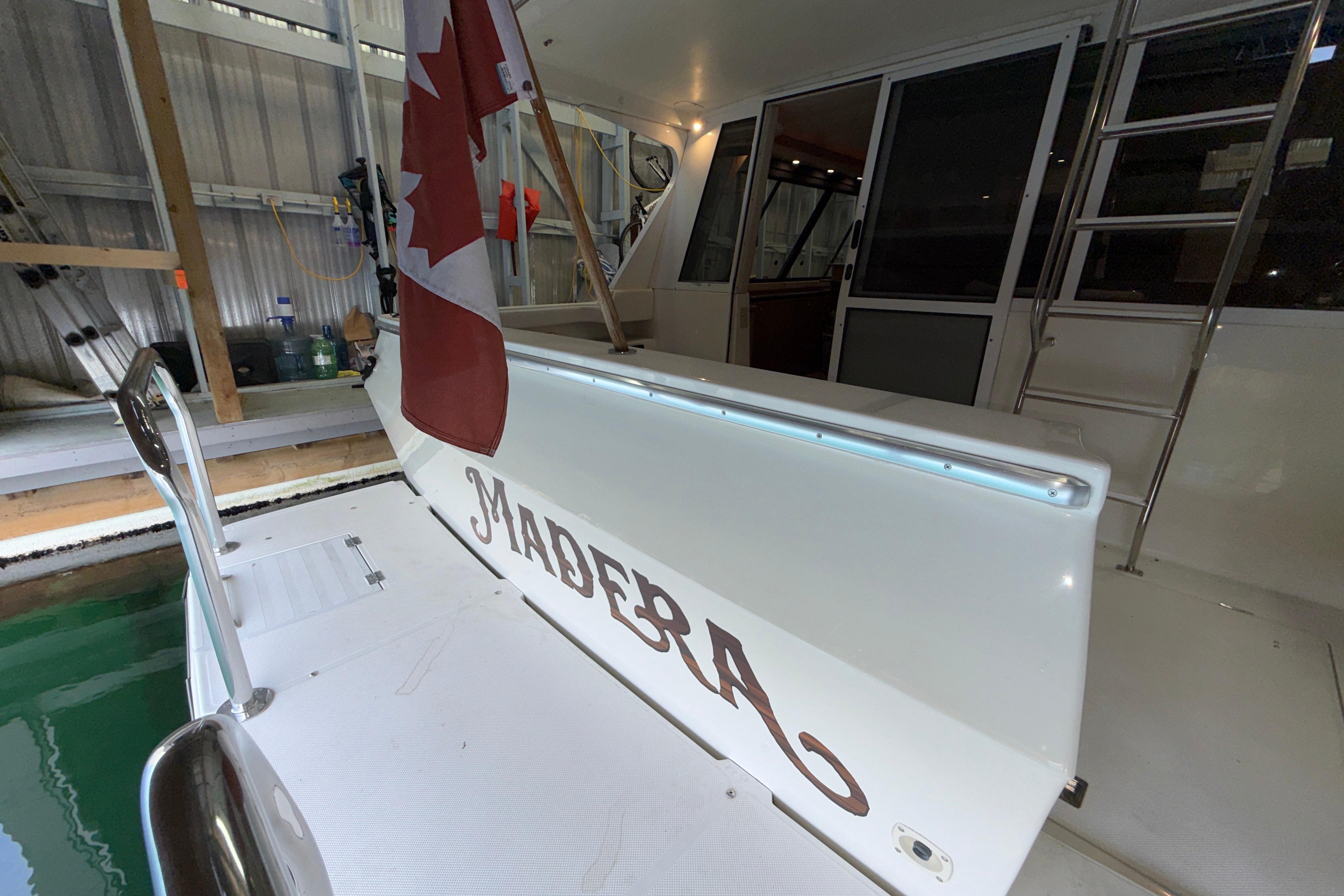 1998 Bayliner 4788 Pilot House Motoryacht with Canadian flag, docked indoors.