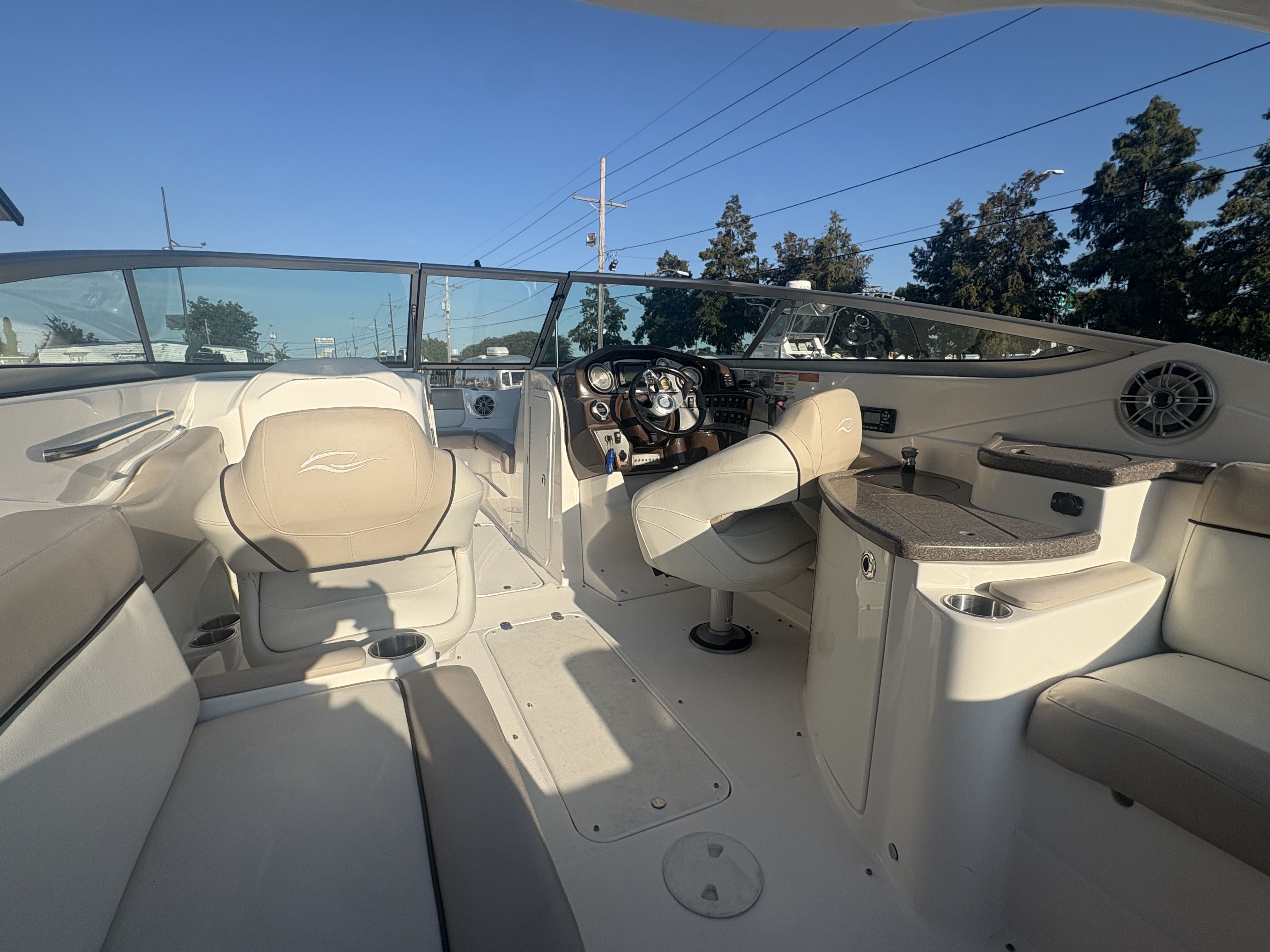 2013 Rinker Captiva 276 boat interior with beige seating and steering console.