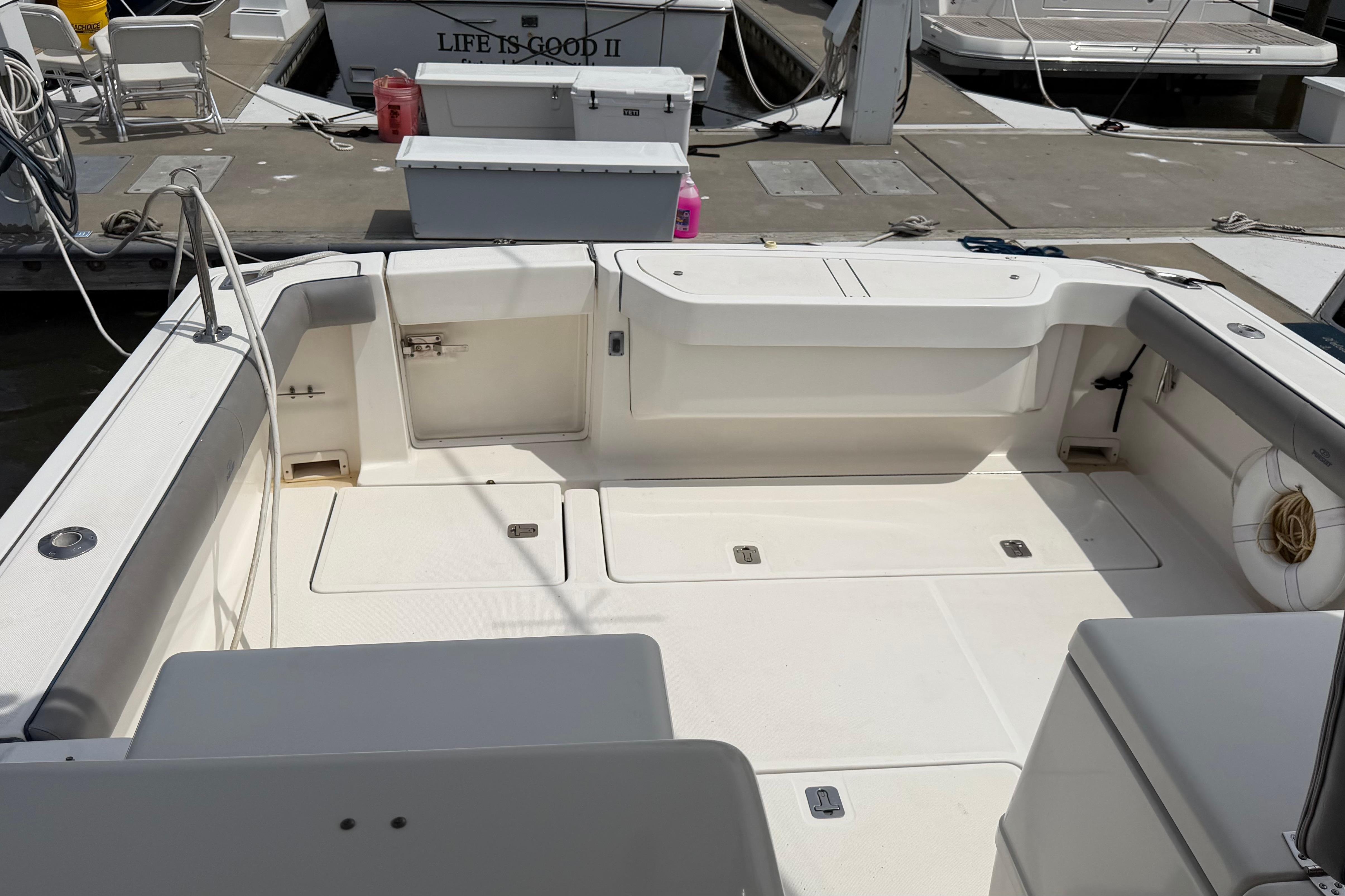 2003 Pursuit 3400 Express boat interior at dock, featuring spacious seating and storage.