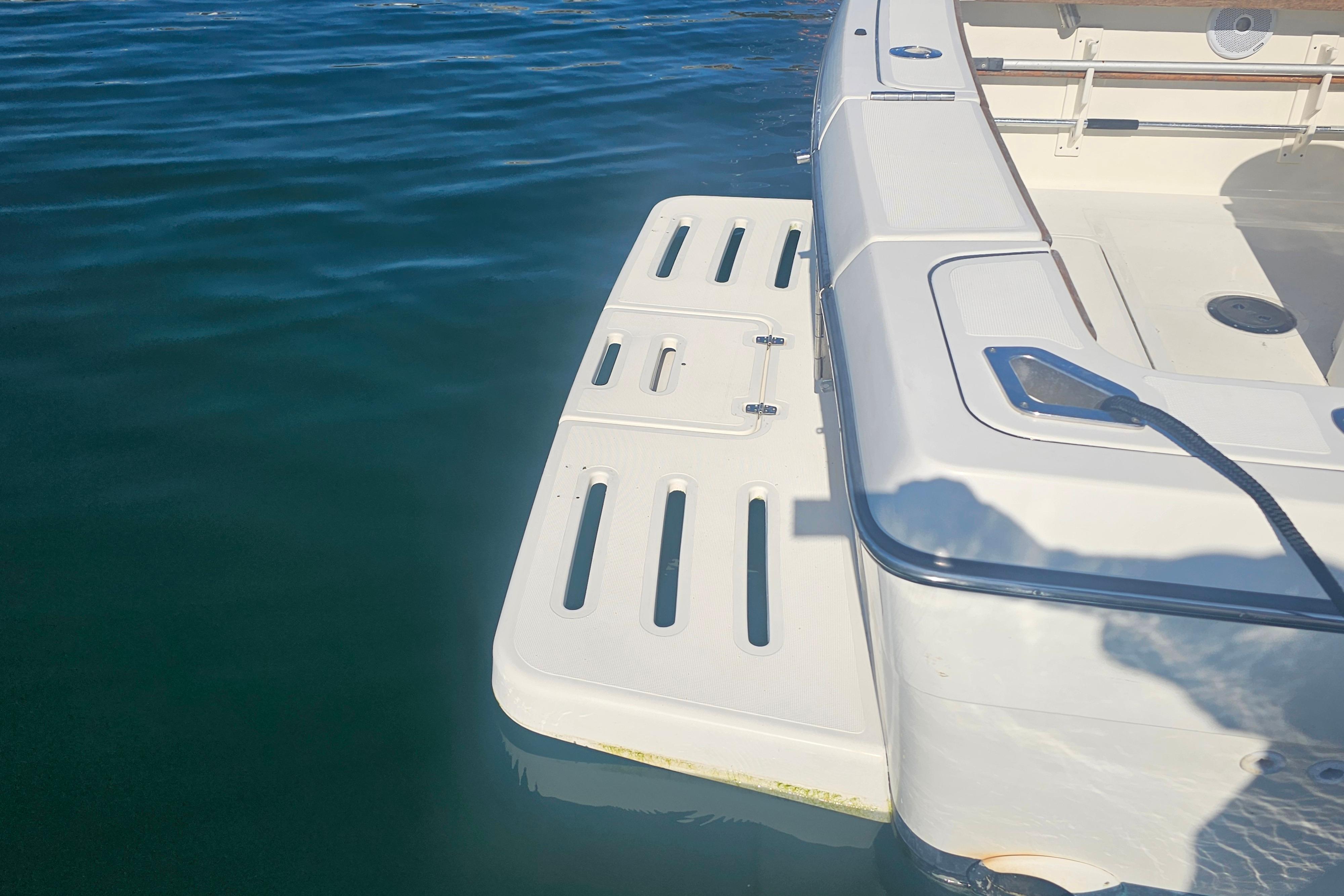 2001 Pursuit 3000 Express boat with swim platform on calm water.