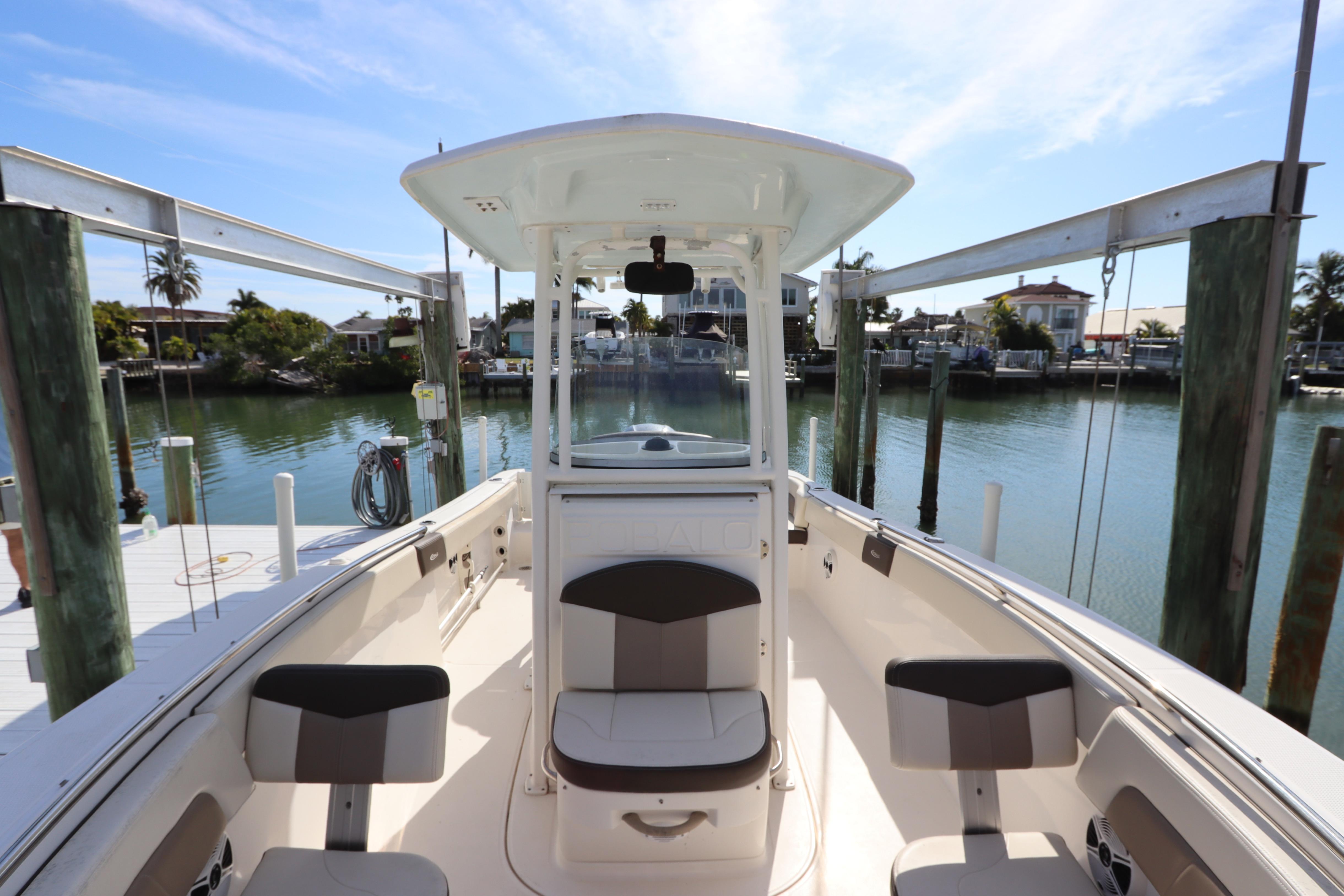 2019 Robalo R242 Center Console boat docked at a scenic waterfront.