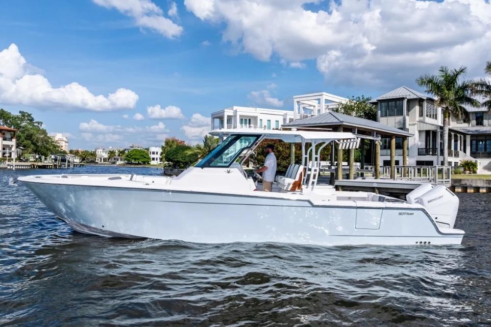 Manufacturer Provided Image: 2026 Bertram 34 CC boat cruising on a sunny day near waterfront homes.