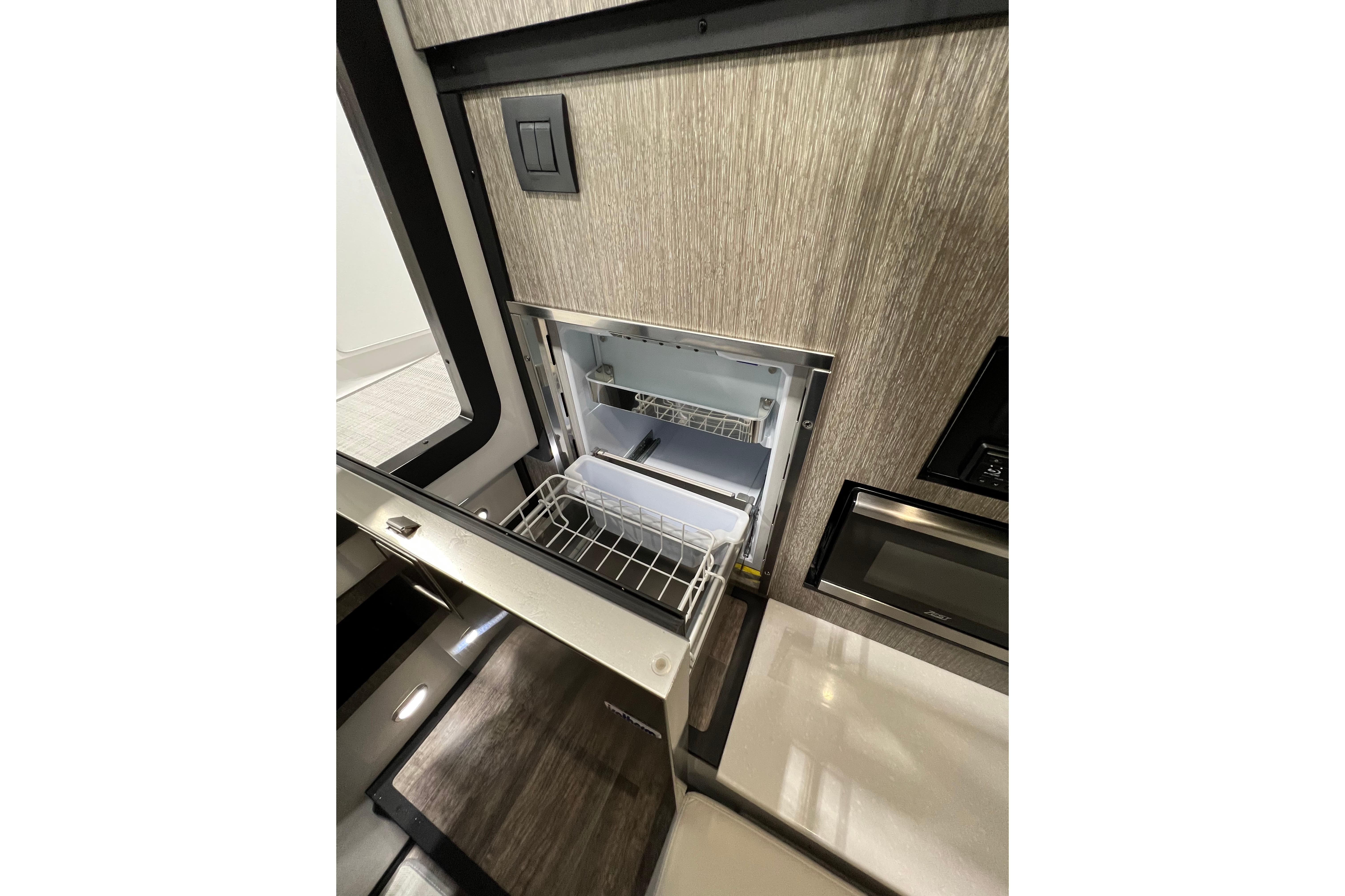 Interior view of 2023 Monterey 378SS Super Sport boat kitchen area with open fridge.