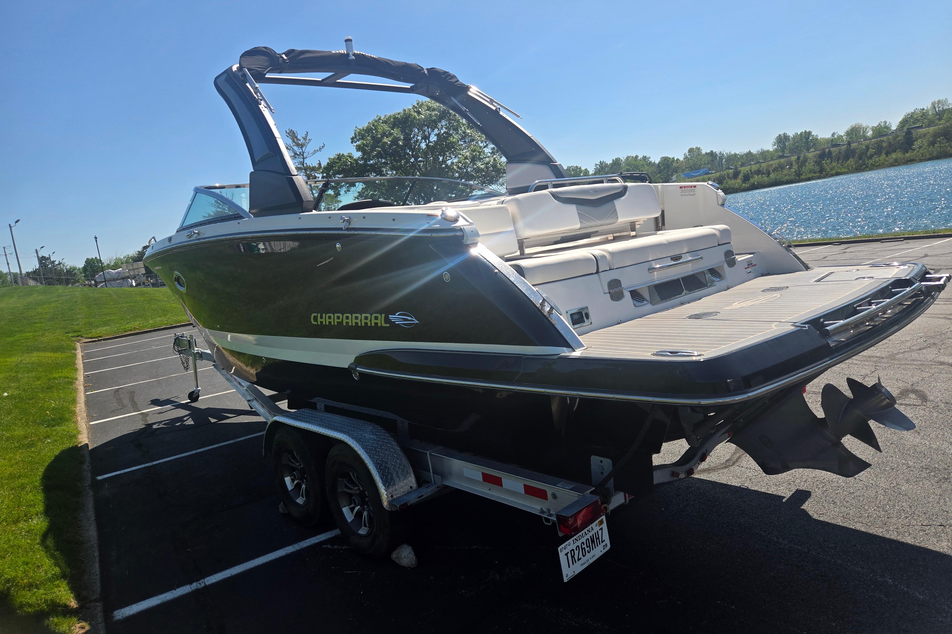 2018 Chaparral 267 SSX boat on trailer near a lake, sunny day.